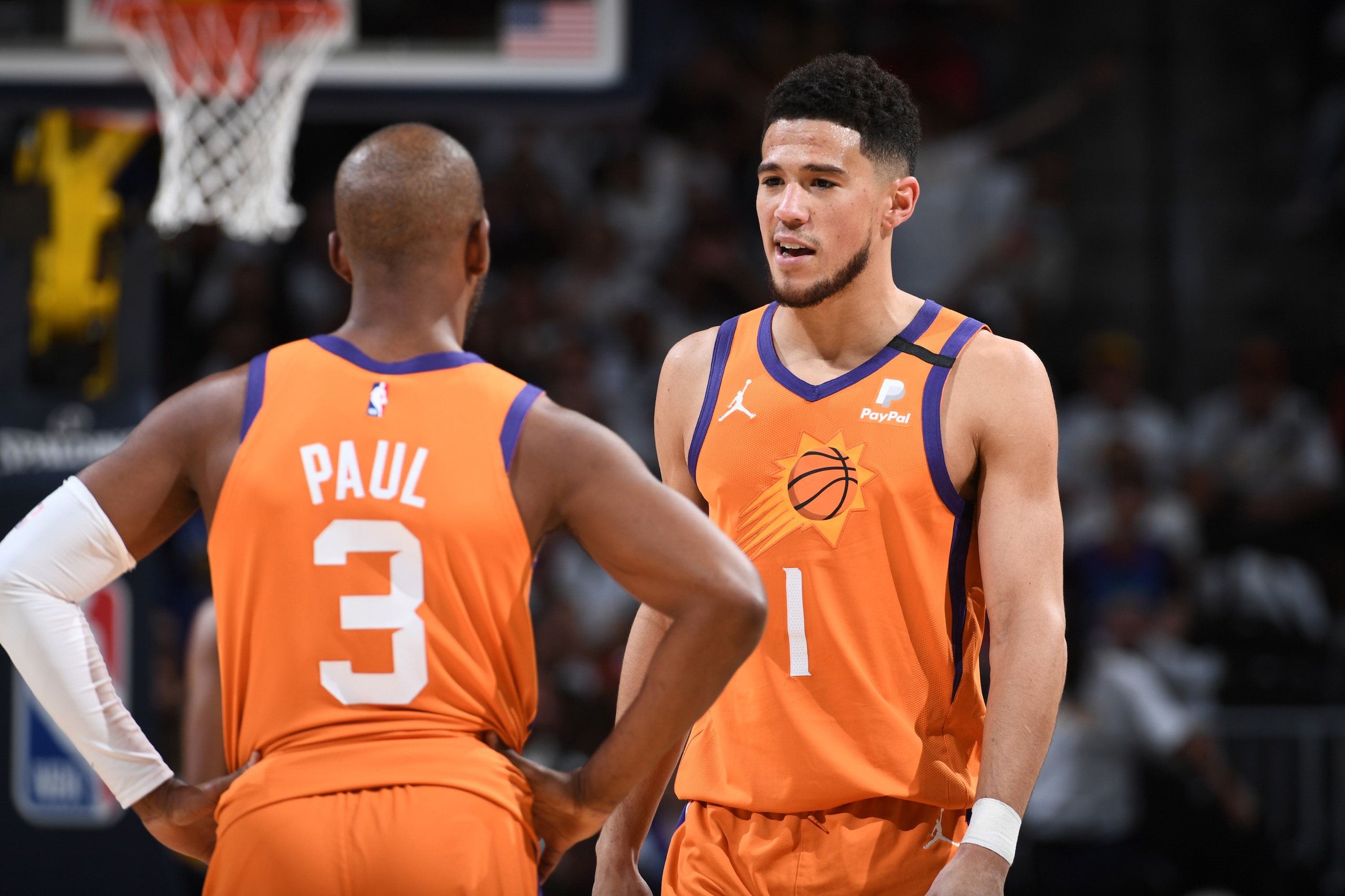 DENVER, CO - JUNE 11: Chris Paul #3 and Devin Booker #1 of the Phoenix Suns talk during Round 2, Game 3 of the 2021 NBA Playoffs on June 11, 2021 at the Ball Arena in Denver, Colorado. NOTE TO USER: User expressly acknowledges and agrees that, by downloading and/or using this Photograph, user is consenting to the terms and conditions of the Getty Images License Agreement. Mandatory Copyright Notice: Copyright 2021 NBAE (Photo by Garrett Ellwood/NBAE via Getty Images)