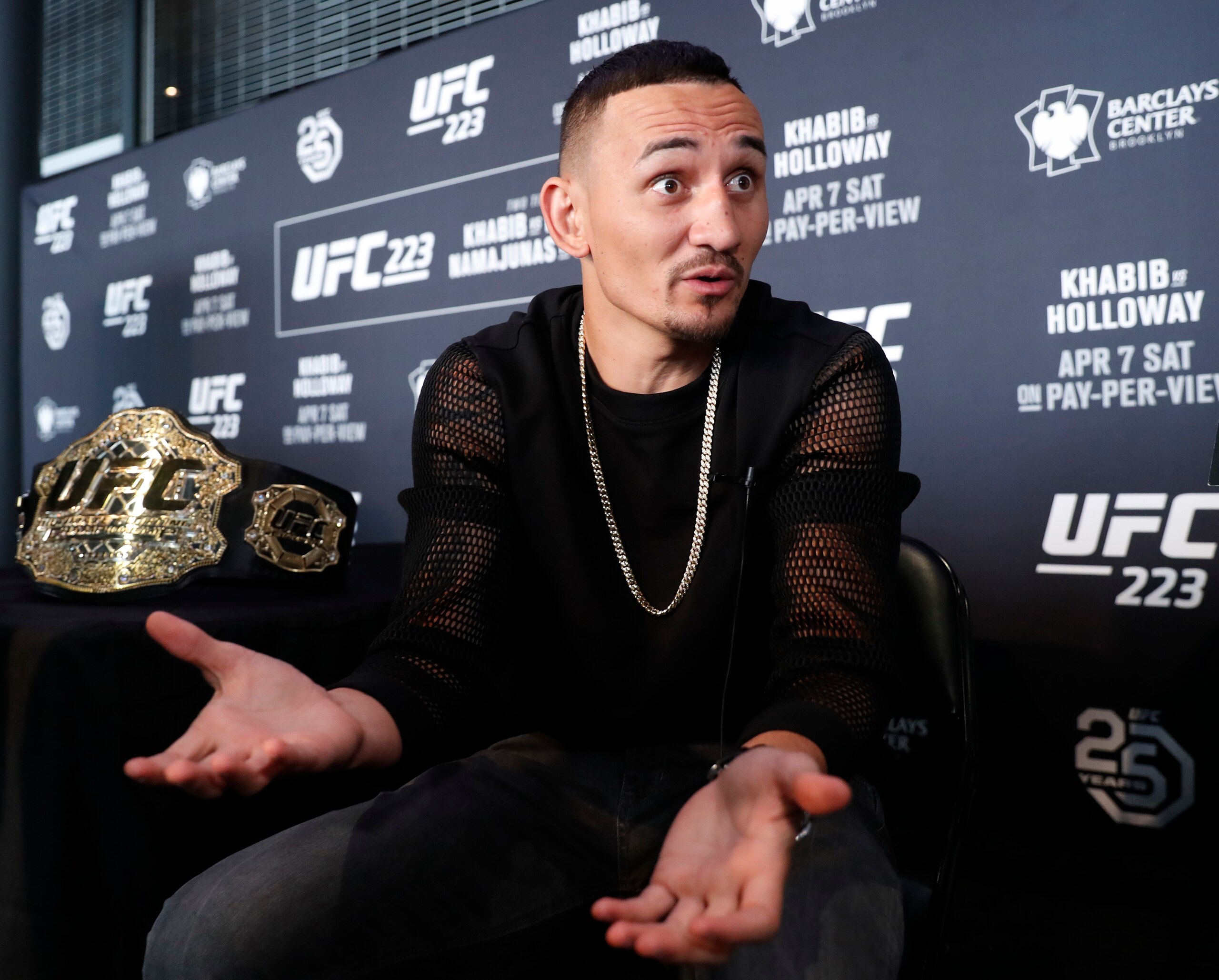 UFC featherweight champion Max Holloway gestures while responding to reporters' questions during Media Day for UFC223, Thursday, April 5, 2018, at the Barclays Center in New York ahead of his upcoming lightweight title fight against Khabib Nurmagomedov. (AP Photo/Kathy Willens)