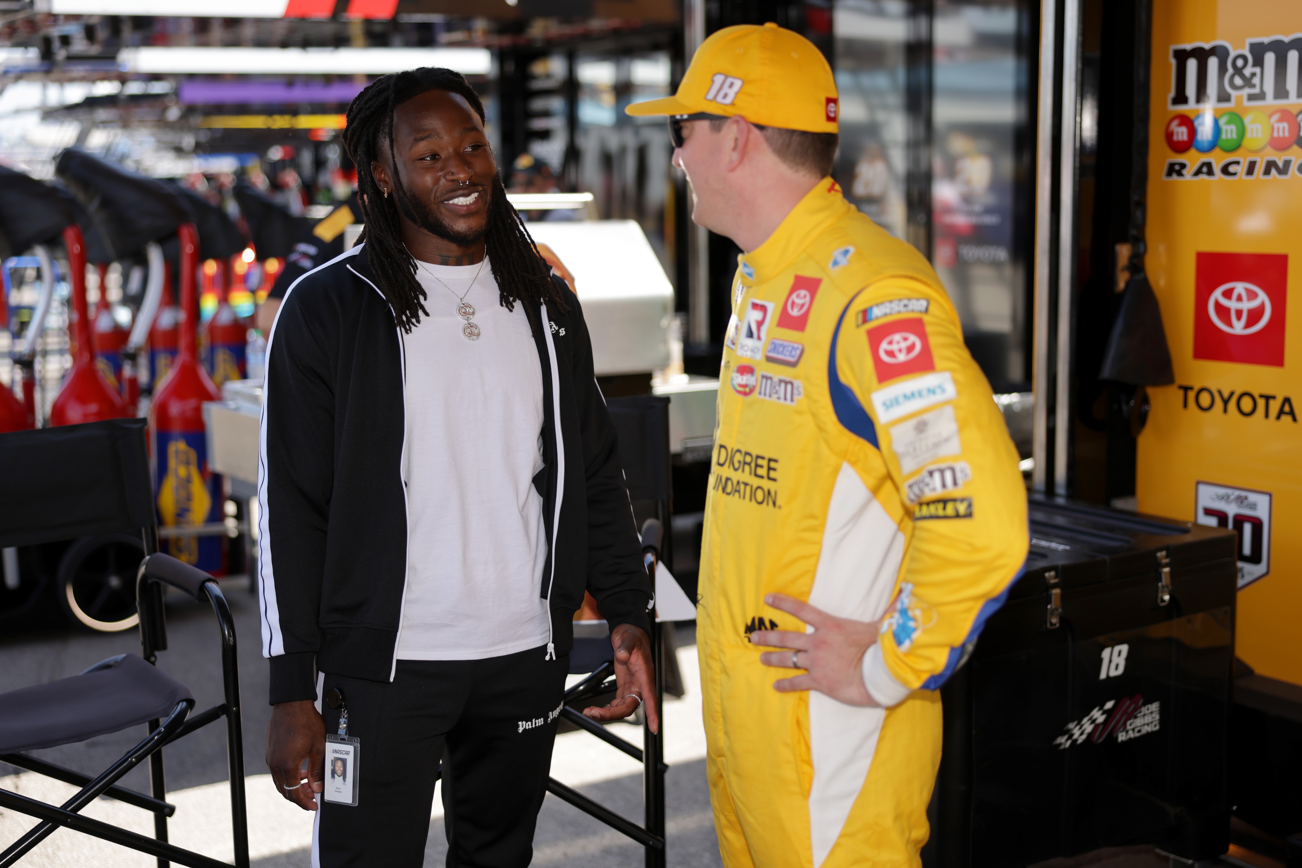 LEBANON, TENNESSEE - JUNE 20: NFL player Alvin Kamara of the New Orleans Saints meets with Kyle Busch, driver of the #18 Pedigree Toyota, in the garage area prior to the NASCAR Cup Series Ally 400 at Nashville Superspeedway on June 20, 2021 in Lebanon, Tennessee. (Photo by Donald Page/Getty Images)