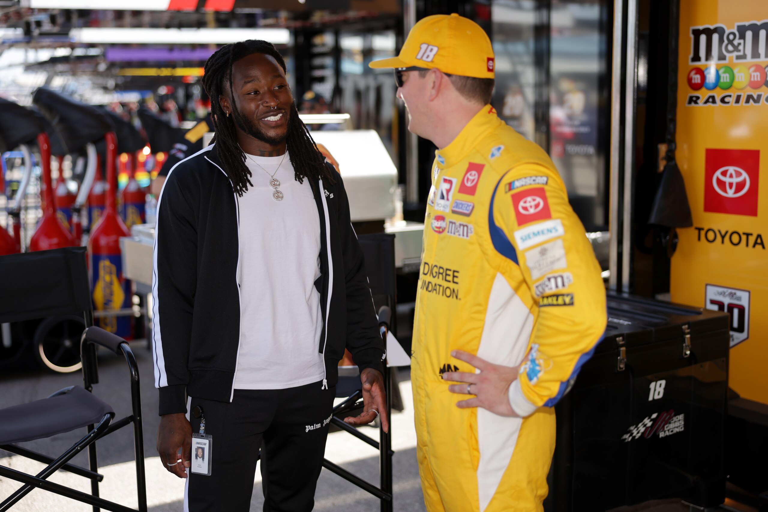 LEBANON, TENNESSEE - JUNE 20: NFL player Alvin Kamara of the New Orleans Saints meets with Kyle Busch, driver of the #18 Pedigree Toyota, in the garage area prior to the NASCAR Cup Series Ally 400 at Nashville Superspeedway on June 20, 2021 in Lebanon, Tennessee. (Photo by Donald Page/Getty Images)