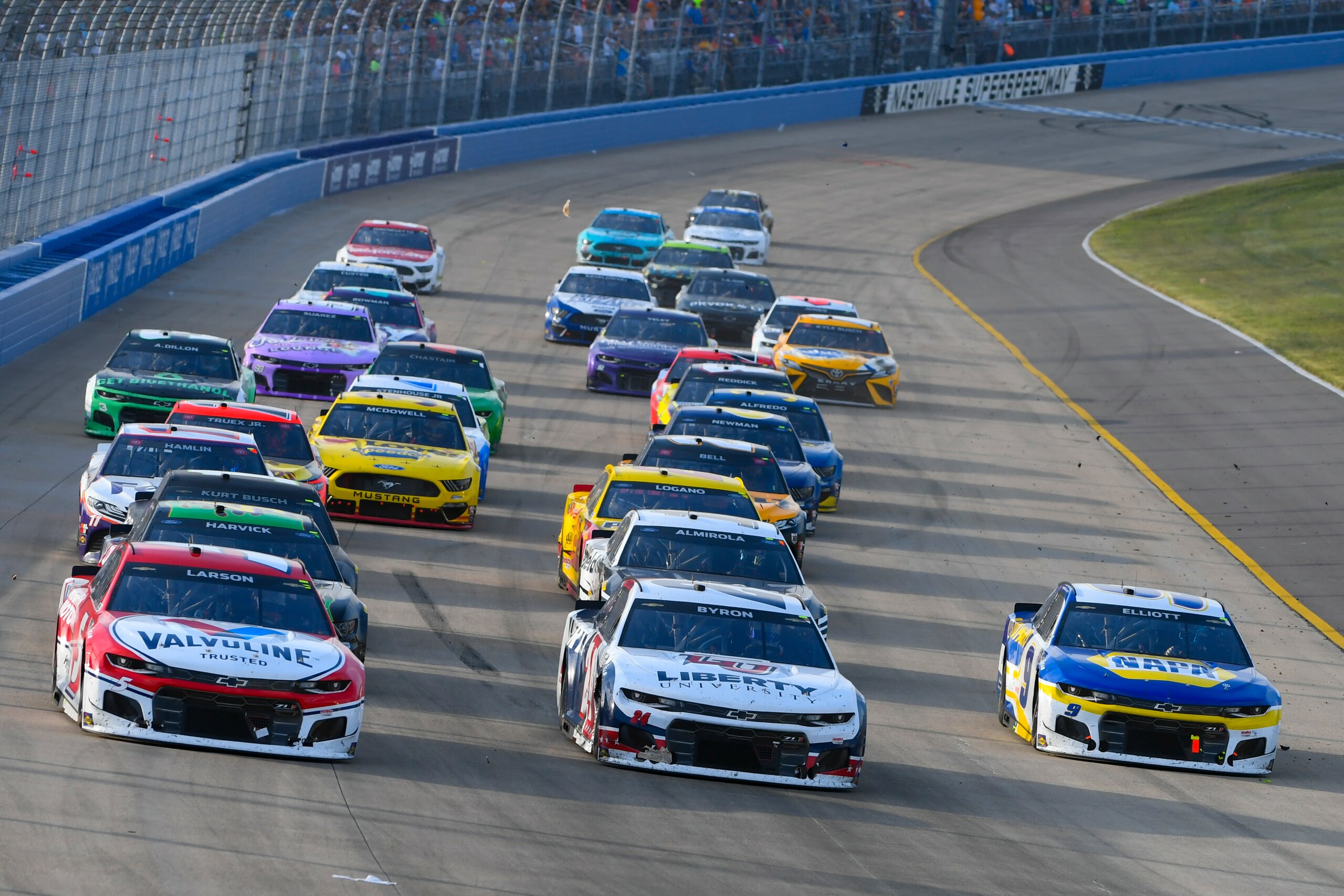 Kyle Larson, left, William Byron, and Chase Elliott run three-wide during Stage 3 of a NASCAR Cup Series auto race Sunday, June 20, 2021, in Lebanon, Tenn. (AP Photo/John Amis)