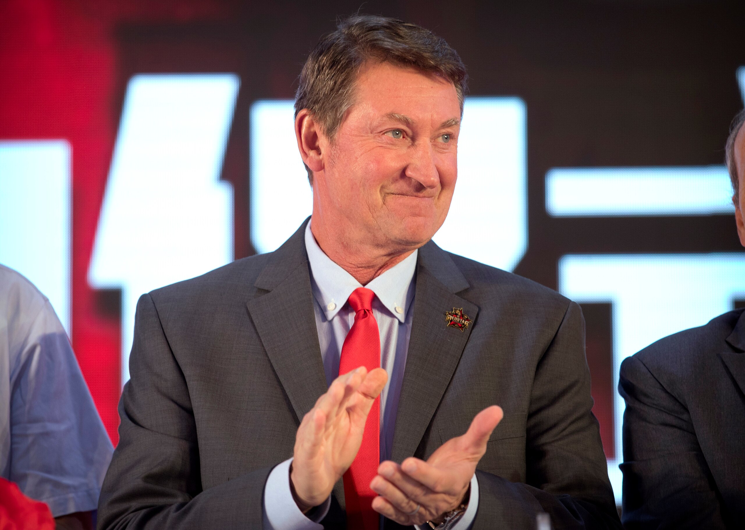 Former NHL hockey player Wayne Gretzky applauds during a promotional event for the Beijing Kunlun Red Star hockey team in his role as global ambassador for the team, part of the Russia-based Kontinental Hockey League, in Beijing, Thursday, Sept. 13, 2018. Gretzky says the NHL should again allow its players to compete in the Winter Olympics because sending the world's top hockey players is "always much better for everyone." (AP Photo/Mark Schiefelbein)
