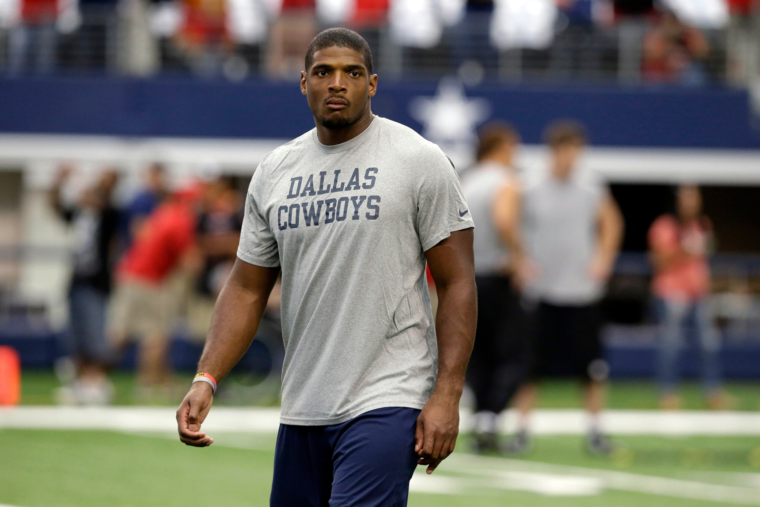 This photo taken Sept. 7, 2014, shows former Dallas Cowboys Michael Sam walking on the field before the first half of an NFL football game in Arlington, Texas. Sam said in a TV documentary that aired Saturday, Dec. 27, 2014,  that coming out as gay was the right thing to do. He'd have preferred the news come out after he informed the team that drafted him. "It didn't need to be public," Sam said. "Why do gay people have to do it?" (AP Photo/LM Otero)