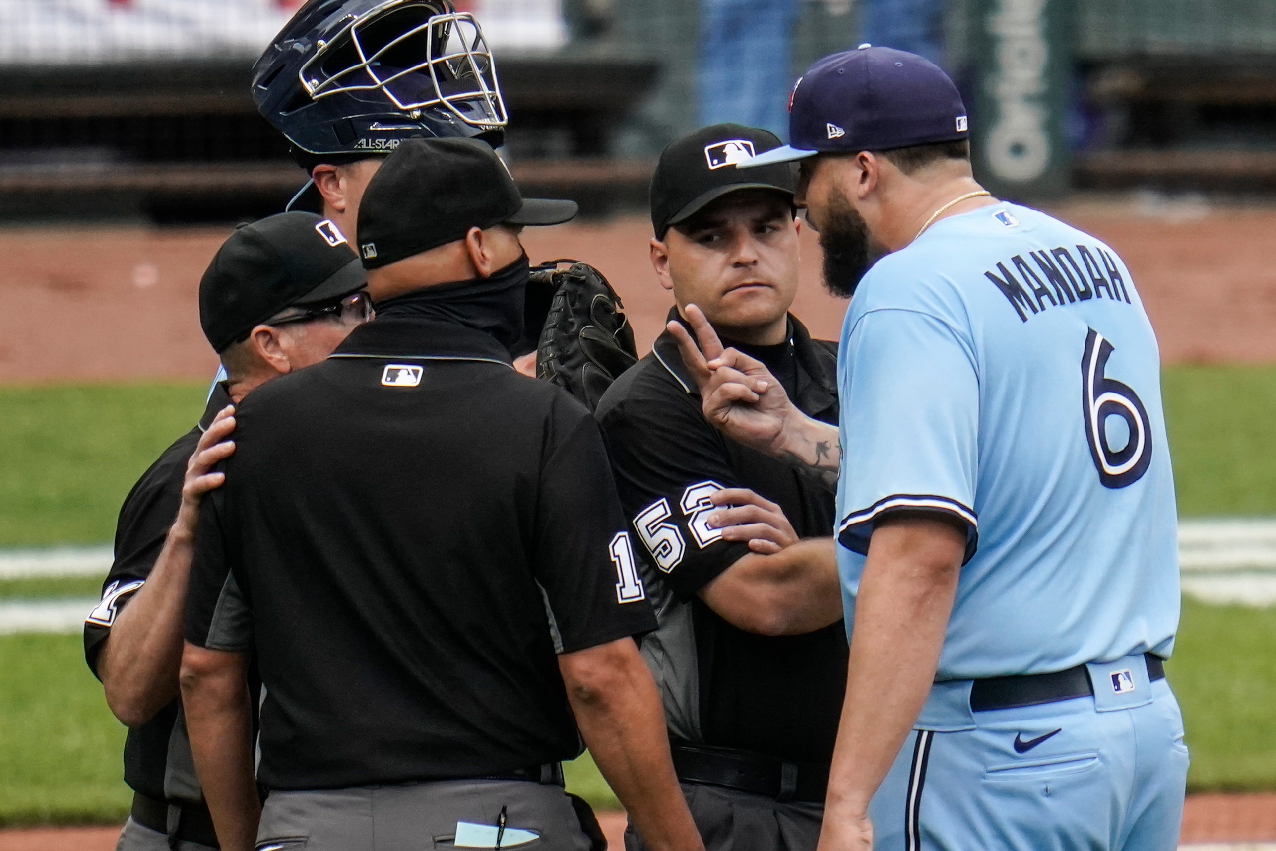 Toronto Blue Jays starting pitcher Alek Manoah, right, talks with umpires, from left, Jerry Meals, Vic Carapazza and Jansen Visconti after Manoah was ejected in the fourth inning of a baseball game against the Baltimore Orioles, Saturday, June 19, 2021, in Baltimore. The incident happened as a result of Manoah hitting Orioles' Maikel Franco with a pitch after Manoah gave up back-to-back home runs to Ryan Mountcastle and DJ Stewart. (AP Photo/Julio Cortez)