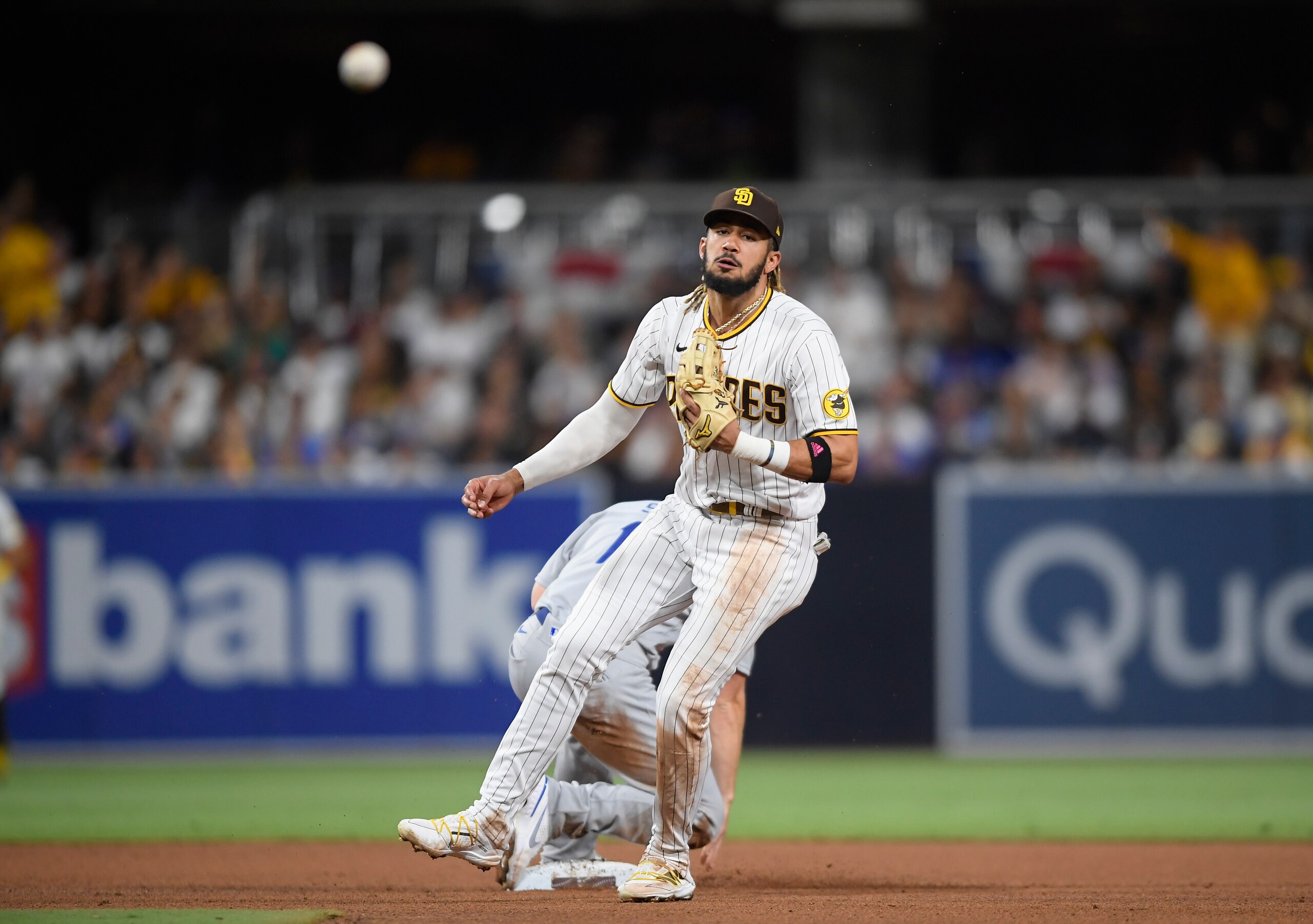 San Diego Padres shortstop Fernando Tatis Jr. (23) throws over Will Smith (16) as he tries to turn a double play during the fourth inning of a baseball game Wednesday, June 23, 2021, in San Diego. Tatis was unable to turn the double and was charged with a throwing error. (AP Photo/Denis Poroy)