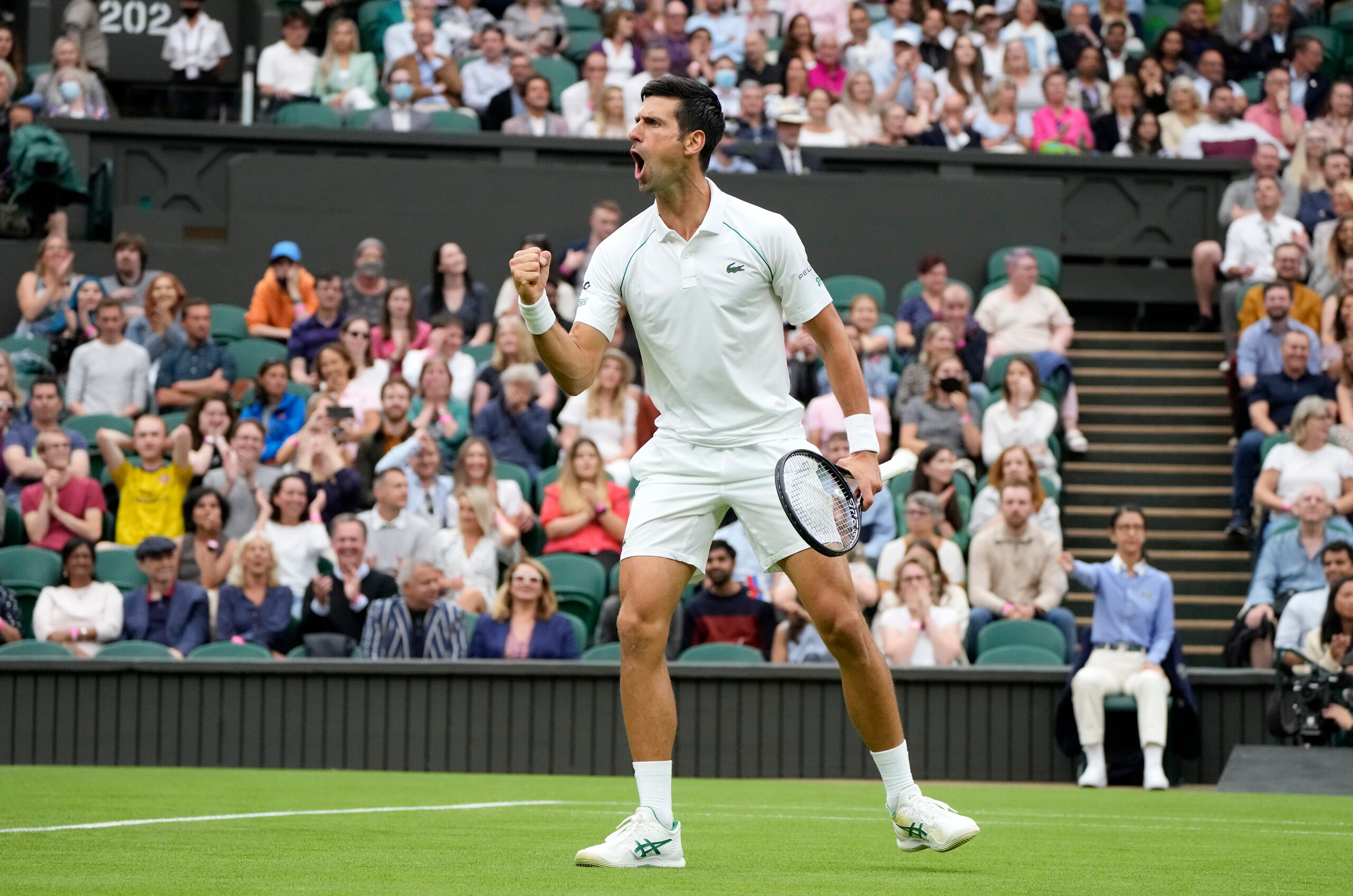 Serbia's Novak Djokovic celebrates winning a point against Britain's Jack Draper during the men's singles match on day one of the Wimbledon Tennis Championships in London, Monday June 28, 2021. (AP Photo/Kirsty Wigglesworth)