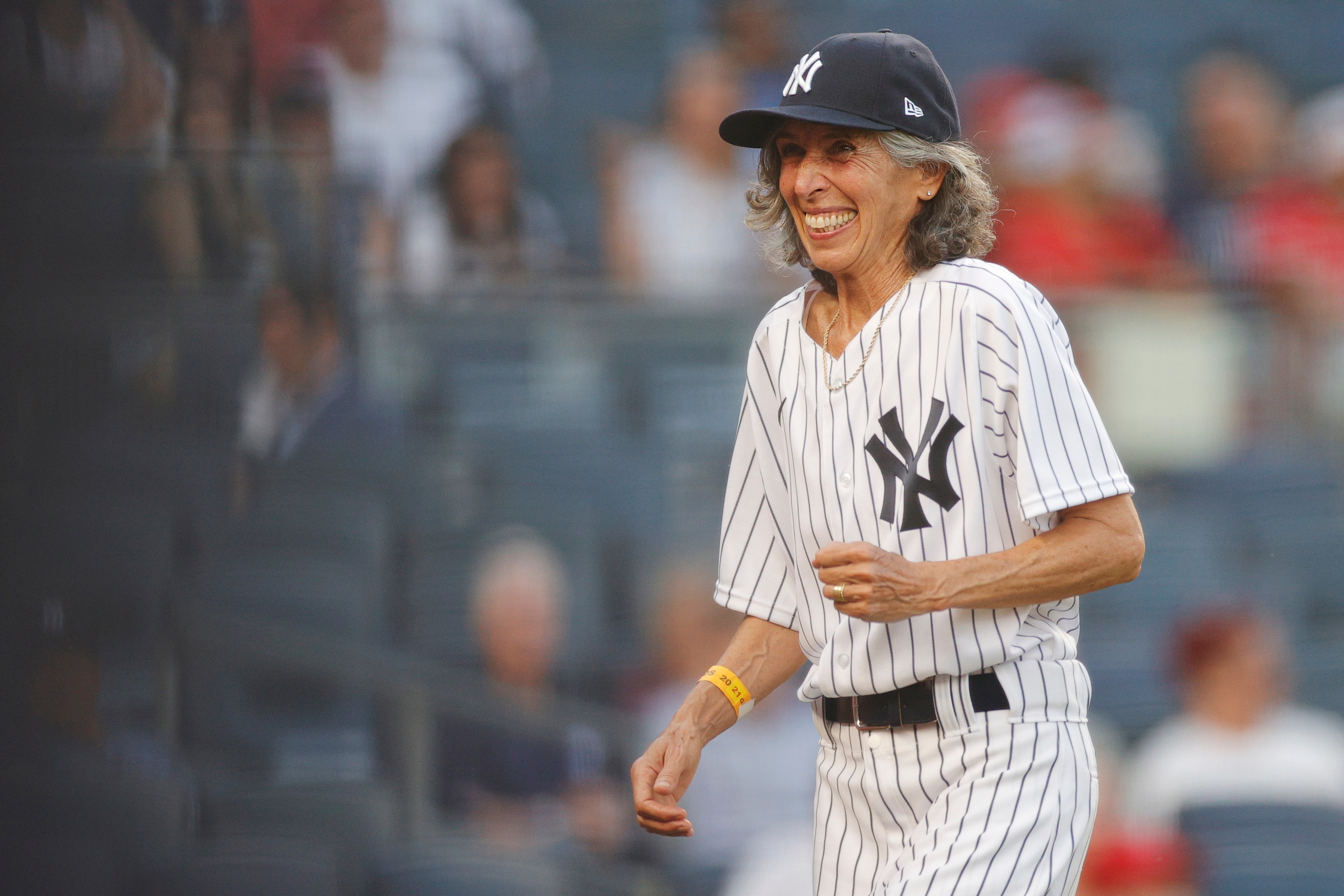 NEW YORK, NEW YORK - JUNE 28: 70-year-old honorary bat girl Gwen Goldman reacts after delivering baseballs to home plate umpire Scott Barry #87 during the first inning against the Los Angeles Angels at Yankee Stadium on June 28, 2021 in the Bronx borough of New York City. (Photo by Sarah Stier/Getty Images)