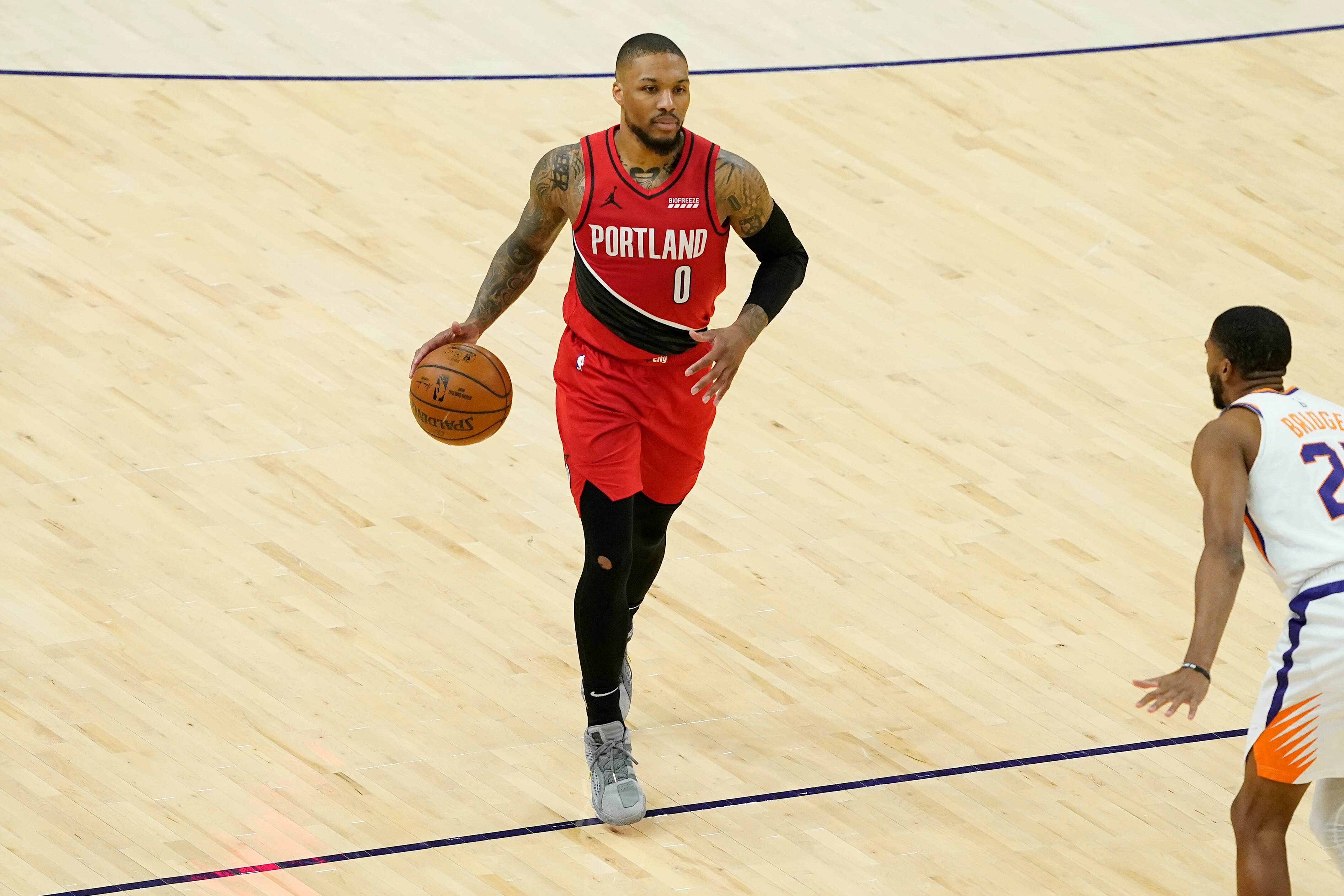 Portland Trail Blazers guard Damian Lillard (0) against the Phoenix Suns during the second half of an NBA basketball game, Thursday, May 13, 2021, in Phoenix. (AP Photo/Matt York)