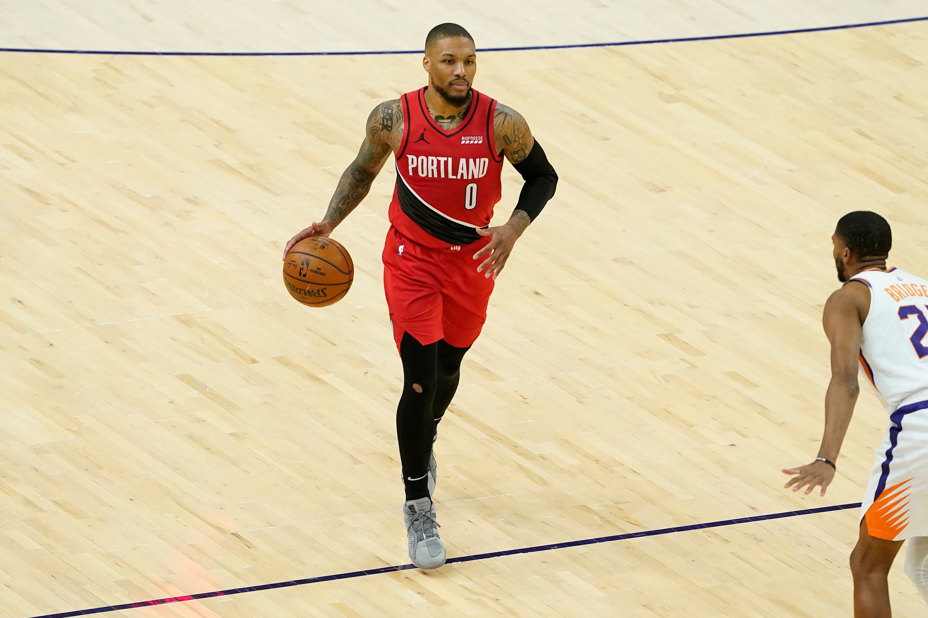 Portland Trail Blazers guard Damian Lillard (0) against the Phoenix Suns during the second half of an NBA basketball game, Thursday, May 13, 2021, in Phoenix. (AP Photo/Matt York)