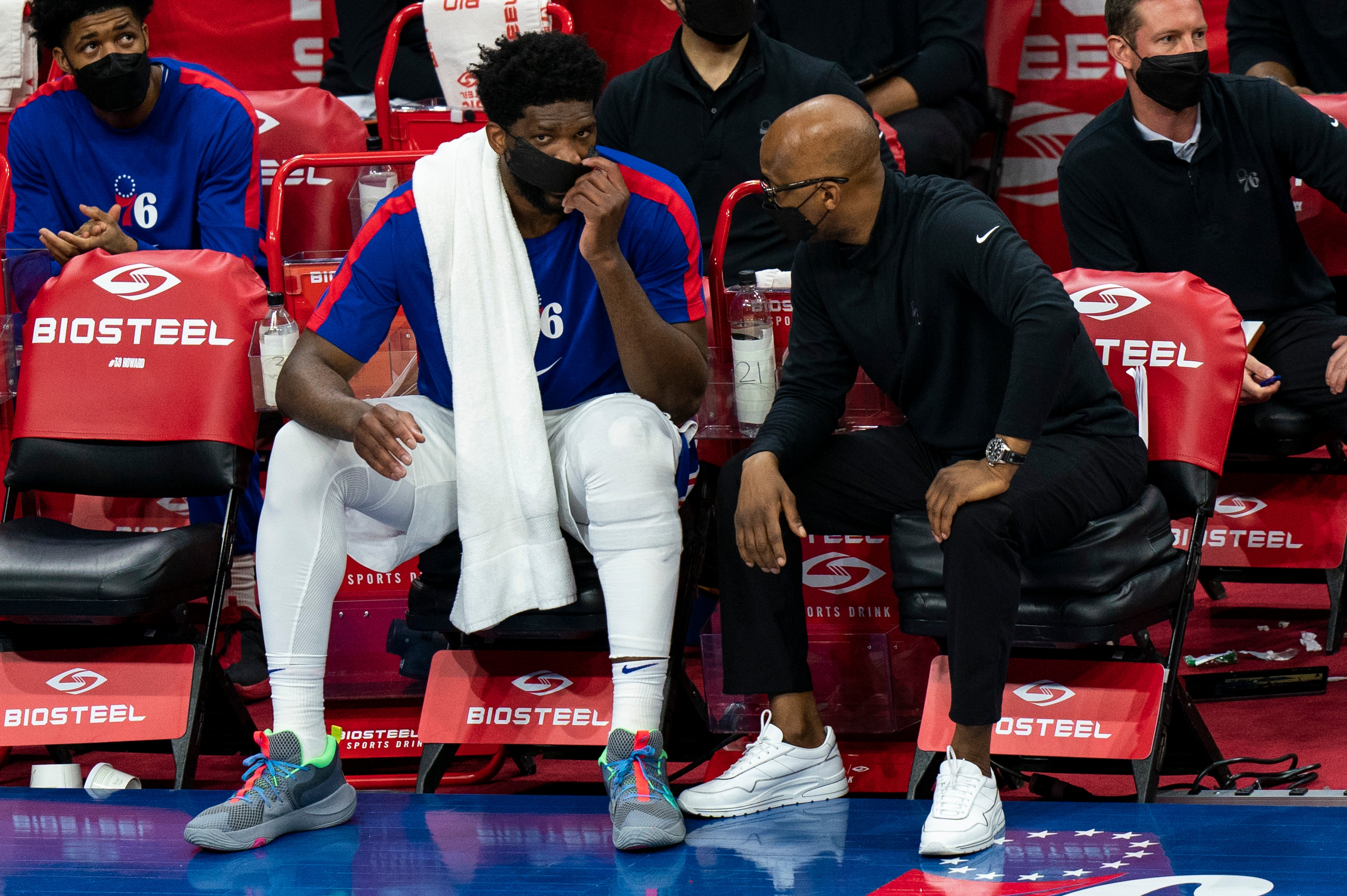 Philadelphia 76ers' Joel Embiid, left, talks with assistant coach Sam Cassell, right, during the second half of an NBA basketball game against the Minnesota Timberwolves, Saturday, April 3, 2021, in Philadelphia. (AP Photo/Chris Szagola)