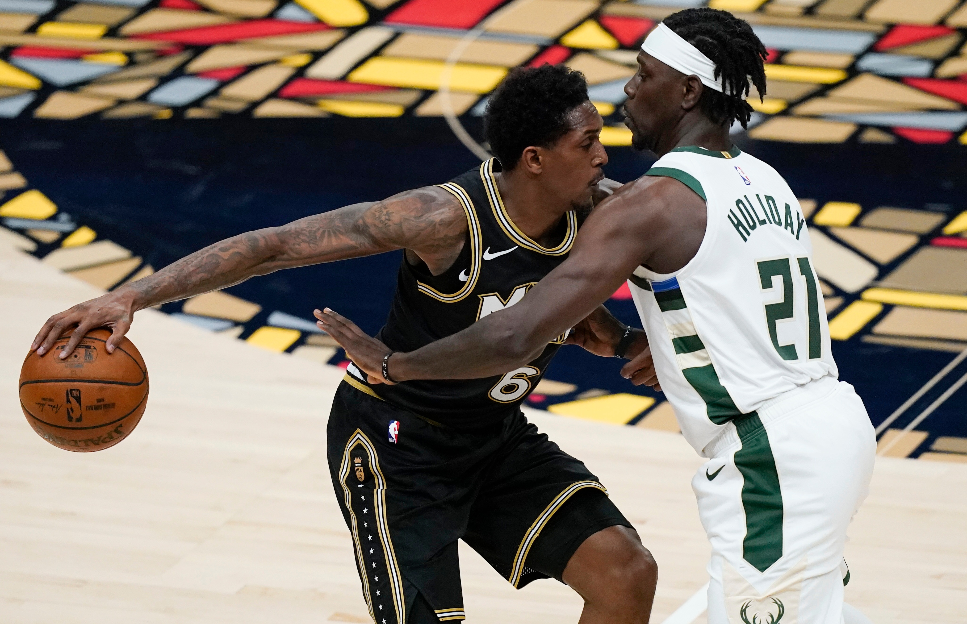 Atlanta Hawks' Lou Williams (6) keeps the ball away from Milwaukee Bucks' Jrue Holiday (21) during the first half of Game 4 of the NBA basketball Eastern Conference finals Tuesday, June 29, 2021, in Atlanta. (AP Photo/Brynn Anderson)