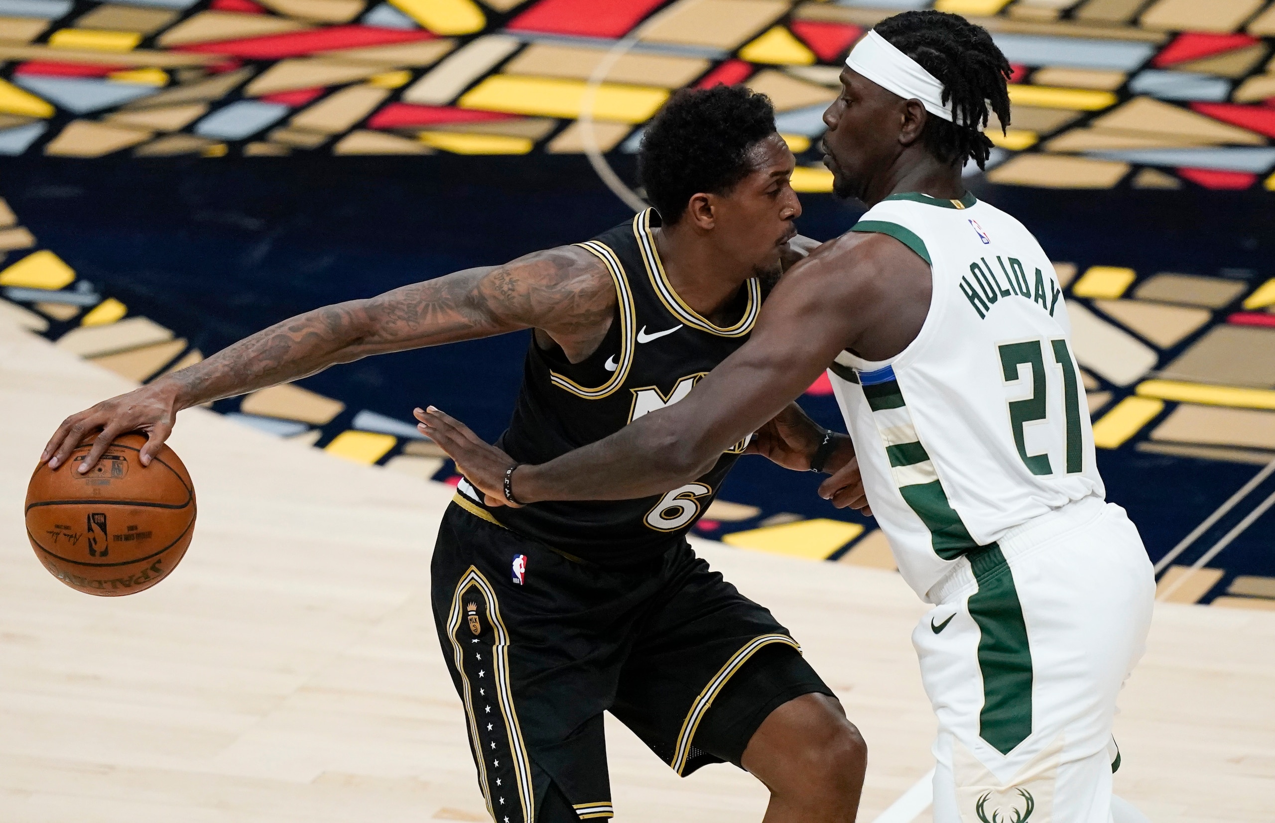 Atlanta Hawks' Lou Williams (6) keeps the ball away from Milwaukee Bucks' Jrue Holiday (21) during the first half of Game 4 of the NBA basketball Eastern Conference finals Tuesday, June 29, 2021, in Atlanta. (AP Photo/Brynn Anderson)