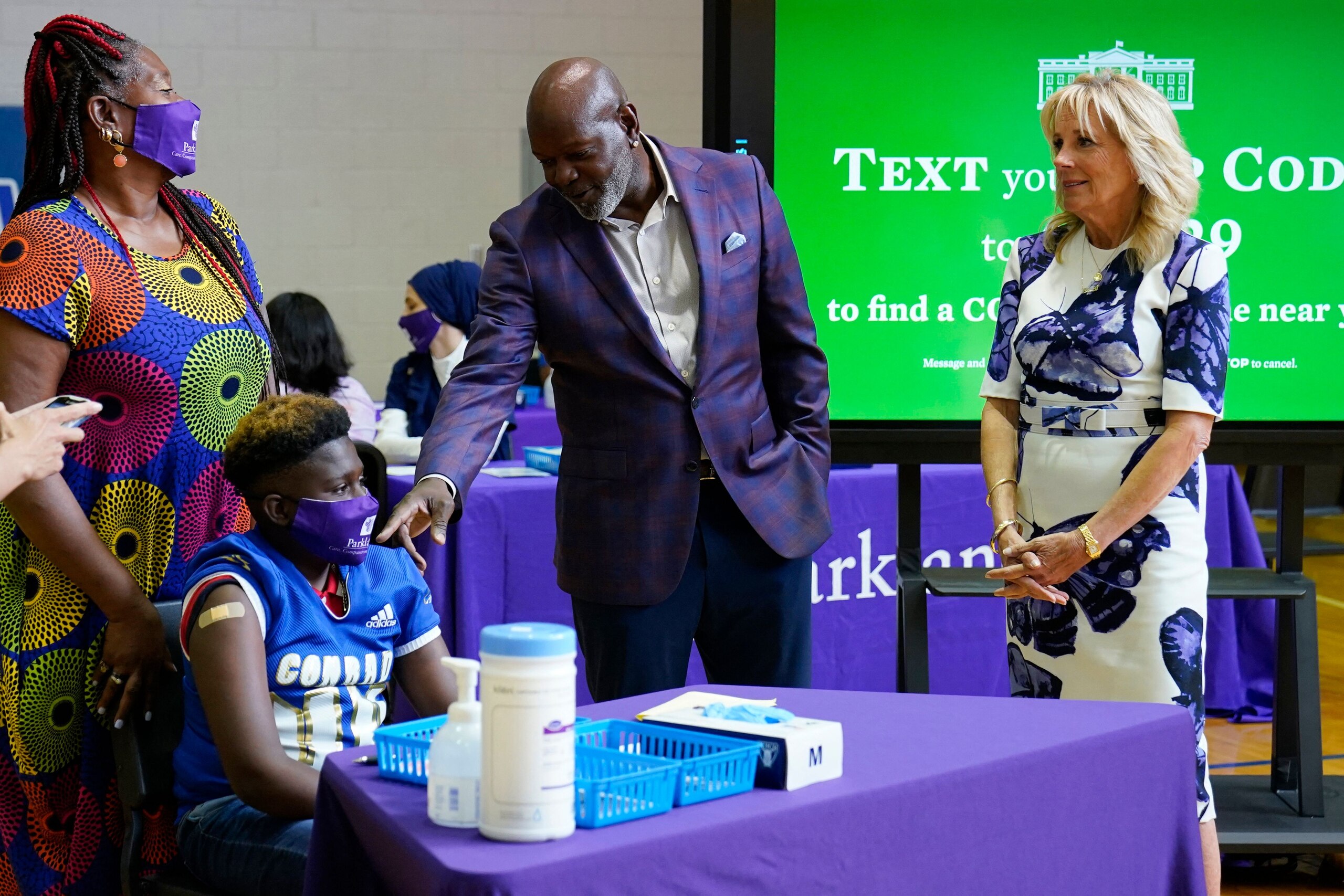Former Dallas Cowboy and Football Hall of Famer Emmitt Smith talks with a Cocid-19 vaccine recipient during a tour of vaccination site at Emmett J. Conrad High School in Dallas, Texas on June 29, 2021. (Photo by Carolyn Kaster / POOL / AFP) (Photo by CAROLYN KASTER/POOL/AFP via Getty Images)