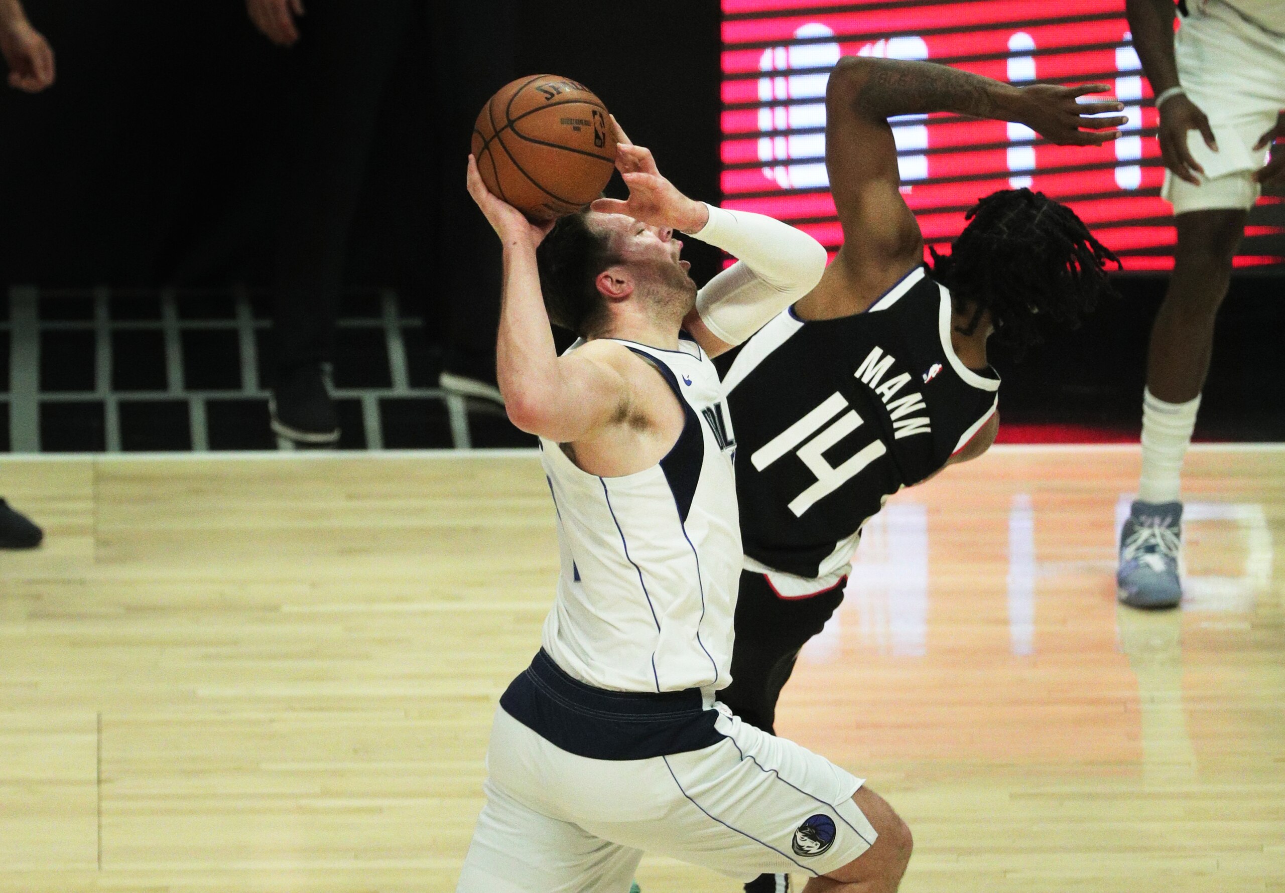 LOS ANGELES, CA - JUNE 6, 2021:LA Clippers guard Terance Mann (14) fouls Dallas Mavericks guard Luka Doncic (77) at the three-point line  in the first half  of game 7 of the first round of the NBA Playoffs at Staples Center on  June 6, 2021 in Los Angeles, California.(Gina Ferazzi / Los Angeles Times via Getty Images)