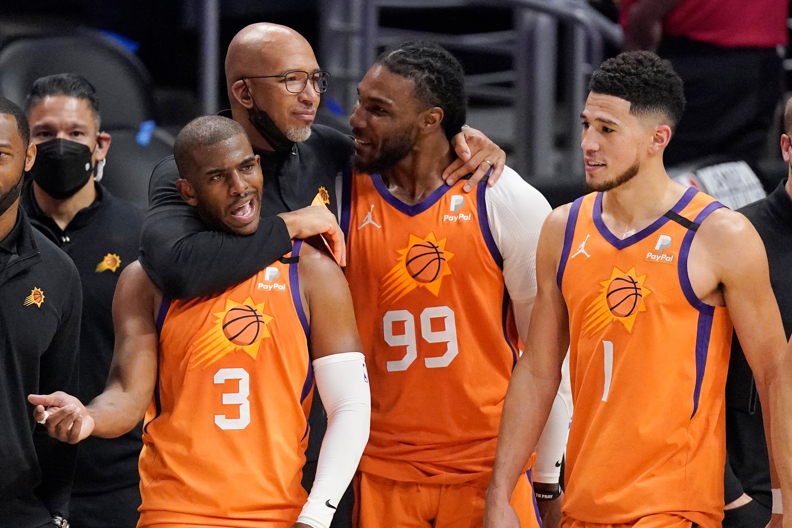 Phoenix Suns head coach Monty Williams, second from left, hugs Chris Paul, left, and Jae Crowder, second from right, as Devin Booker stands by as time runs out in Game 6 of the NBA basketball Western Conference Finals against the Los Angeles Clippers Wednesday, June 30, 2021, in Los Angeles. The Suns won the game 130-103 to take the series 4-2. (AP Photo/Mark J. Terrill)