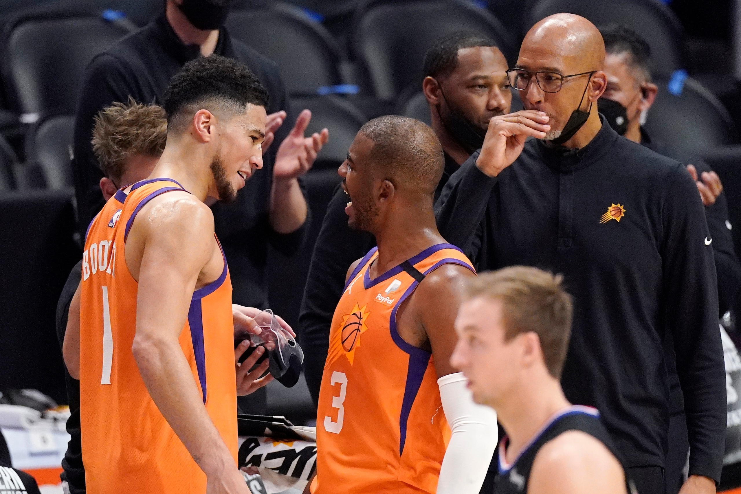 Phoenix Suns guard Devin Booker, left, and guard Chris Paul, center, celebrate as head coach Monty Williams looks on as time runs out in Game 6 of the NBA basketball Western Conference Finals against the Los Angeles Clippers Wednesday, June 30, 2021, in Los Angeles. The Suns won the game 130-103 to take the series 4-2. (AP Photo/Mark J. Terrill)
