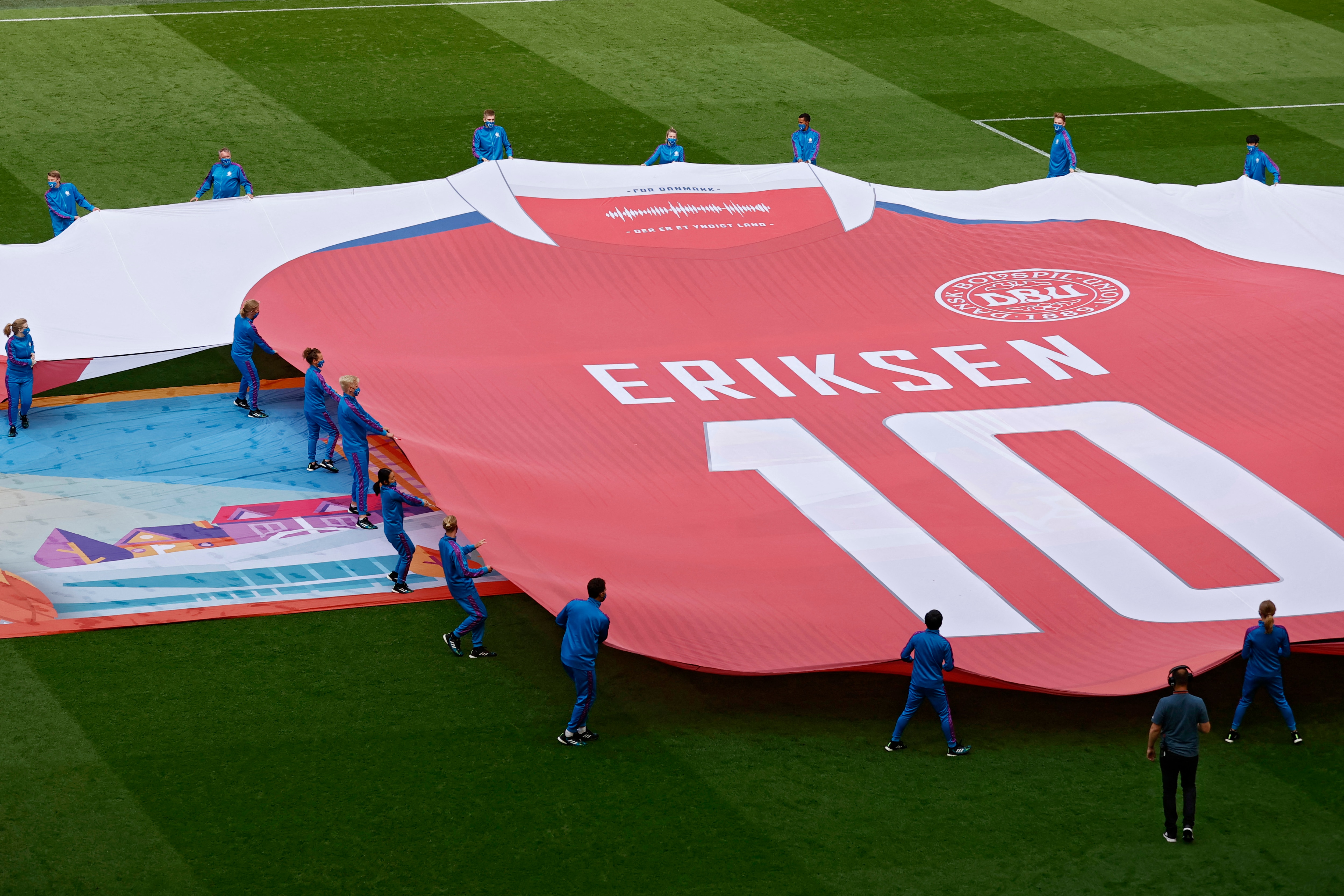 TOPSHOT - Performers display a banner depicting the jersey of Denmark's midfielder Christian Eriksen who suffered a cardiac arrest during a group stage match ahead of the UEFA EURO 2020 round of 16 football match between Wales and Denmark at the Johan Cruyff Arena in Amsterdam on June 26, 2021. (Photo by Koen van Weel / POOL / AFP) (Photo by KOEN VAN WEEL/POOL/AFP via Getty Images)