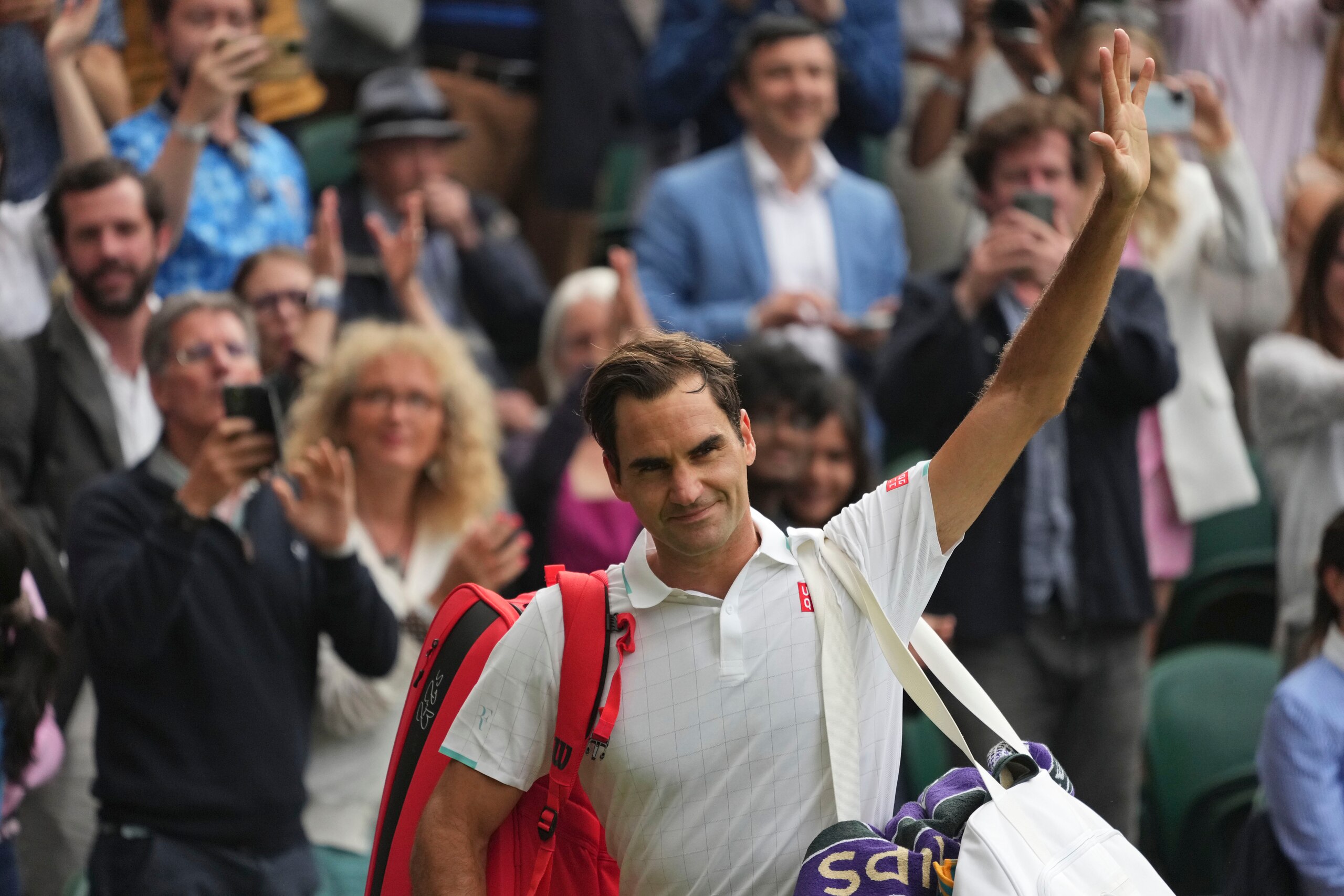 Switzerland's Roger Federer leaves the court after losing to Poland's Hubert Hurkacz during the men's singles quarterfinals match on day nine of the Wimbledon Tennis Championships in London, Wednesday, July 7, 2021. (AP Photo/Alberto Pezzali)