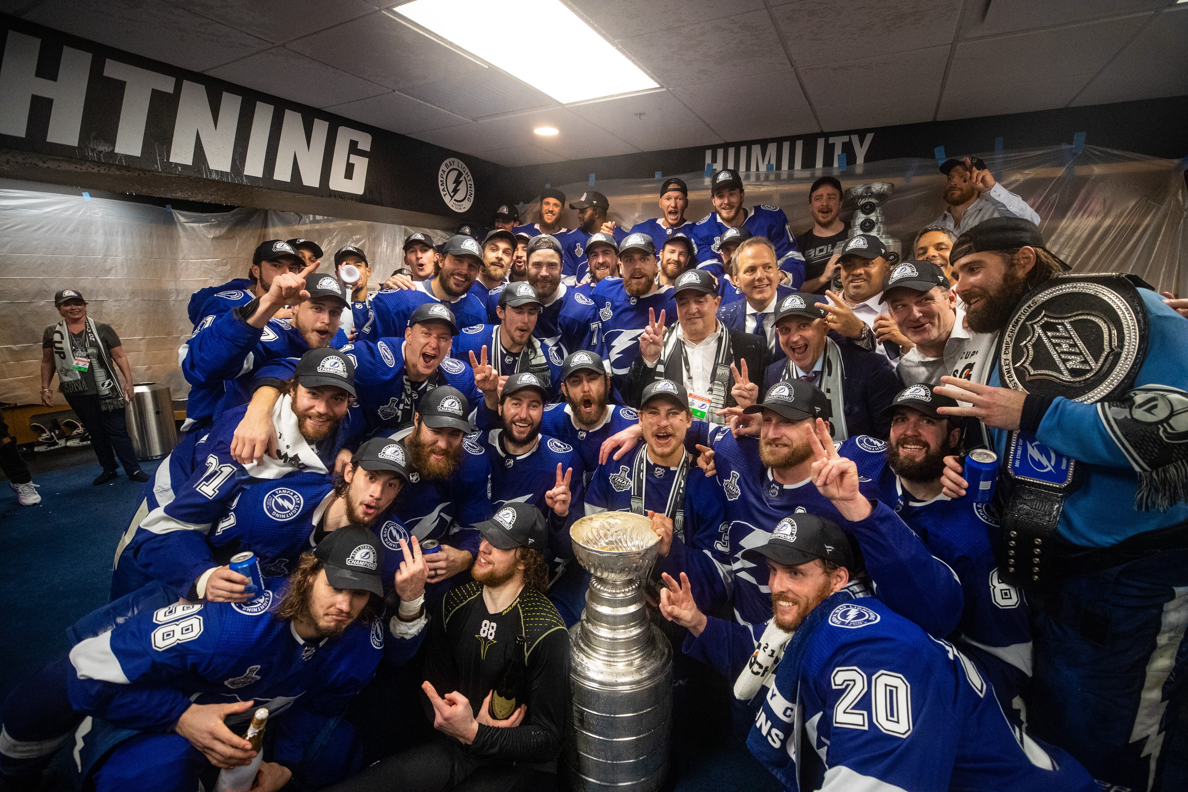 TAMPA, FL - JULY 7: The Tampa Bay Lightning celebrates in the locker room with the Stanley Cup after the Tampa Bay Lightning defeated the Montreal Canadiens in Game Five to win the best of seven game series 4-1 during the Stanley Cup Final of the 2021 Stanley Cup Playoffs at Amalie Arena on July 7, 2021 in Tampa, Florida. (Photo by Scott Audette/NHLI via Getty Images)