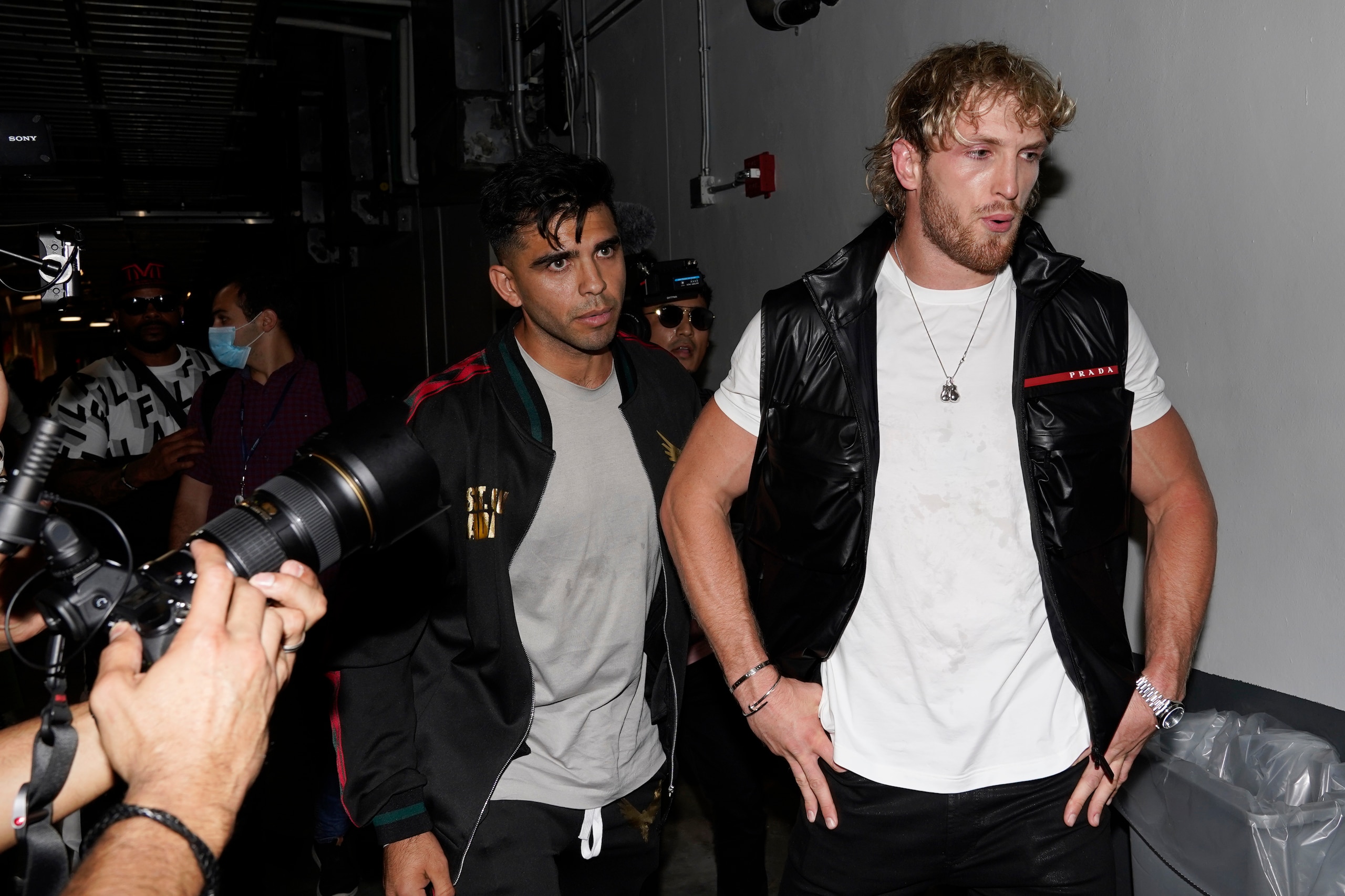 Boxer Logan Paul is escorted by his team after a scuffle broke out between boxer Floyd Mayweather and Paul's brother, Jake Paul, during a news conference Thursday, May 6, 2021, in Miami Gardens, Fla. Mayweather and Paul are scheduled to face off in an exhibition bout June 6.  (AP Photo/Marta Lavandier)
