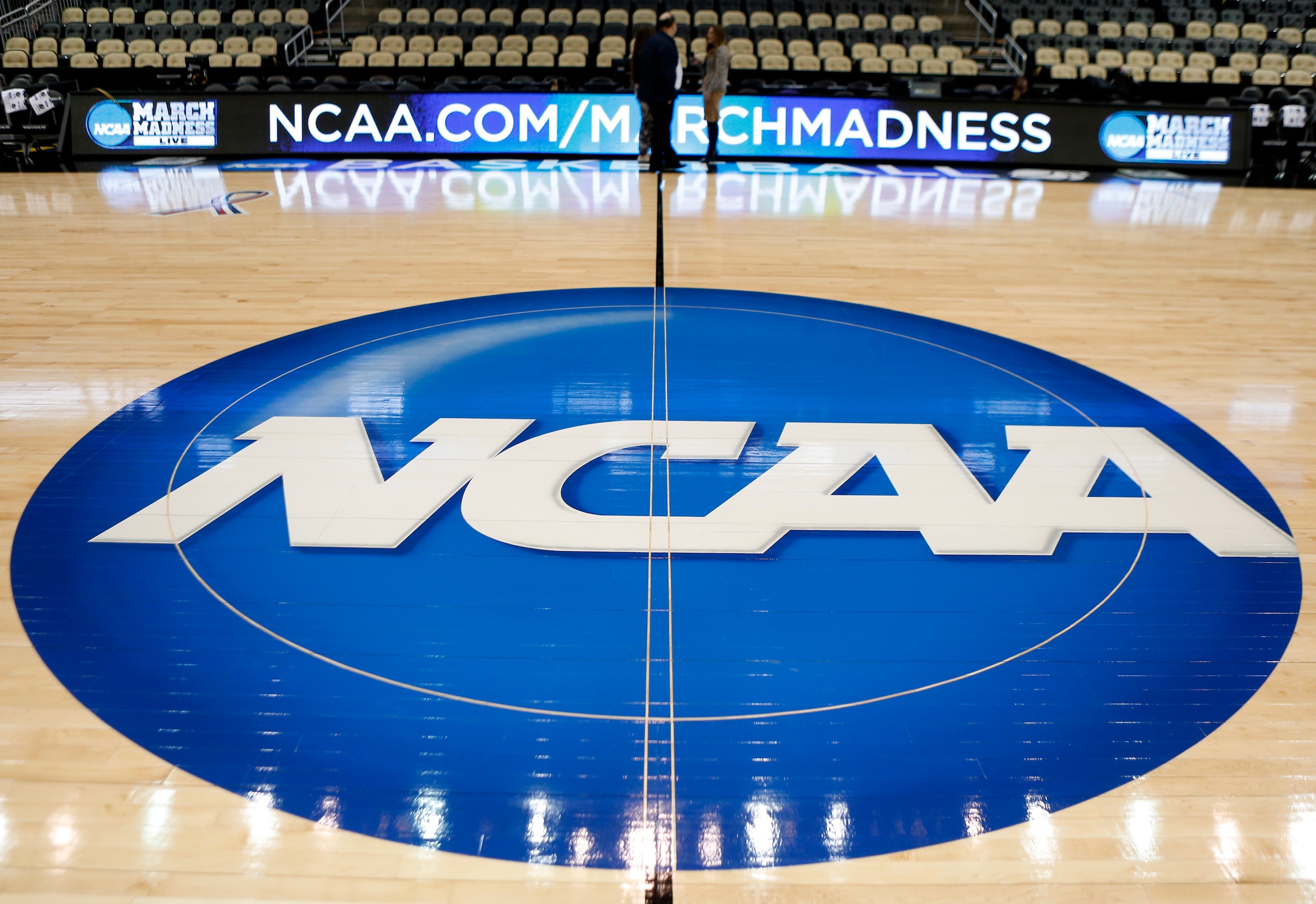 FILE - In this March 18, 2015, file photo, the NCAA logo is at center court as work continues at The Consol Energy Center in Pittsburgh, for the NCAA college basketball second and third round games.  The NCAA and 11 major athletic conferences announced Friday, Feb. 3, 2017,  they have agreed to pay $208.7 million to settle a federal class-action lawsuit filed by former college athletes who claimed the value of their scholarships was illegally capped.(AP Photo/Keith Srakocic, File)