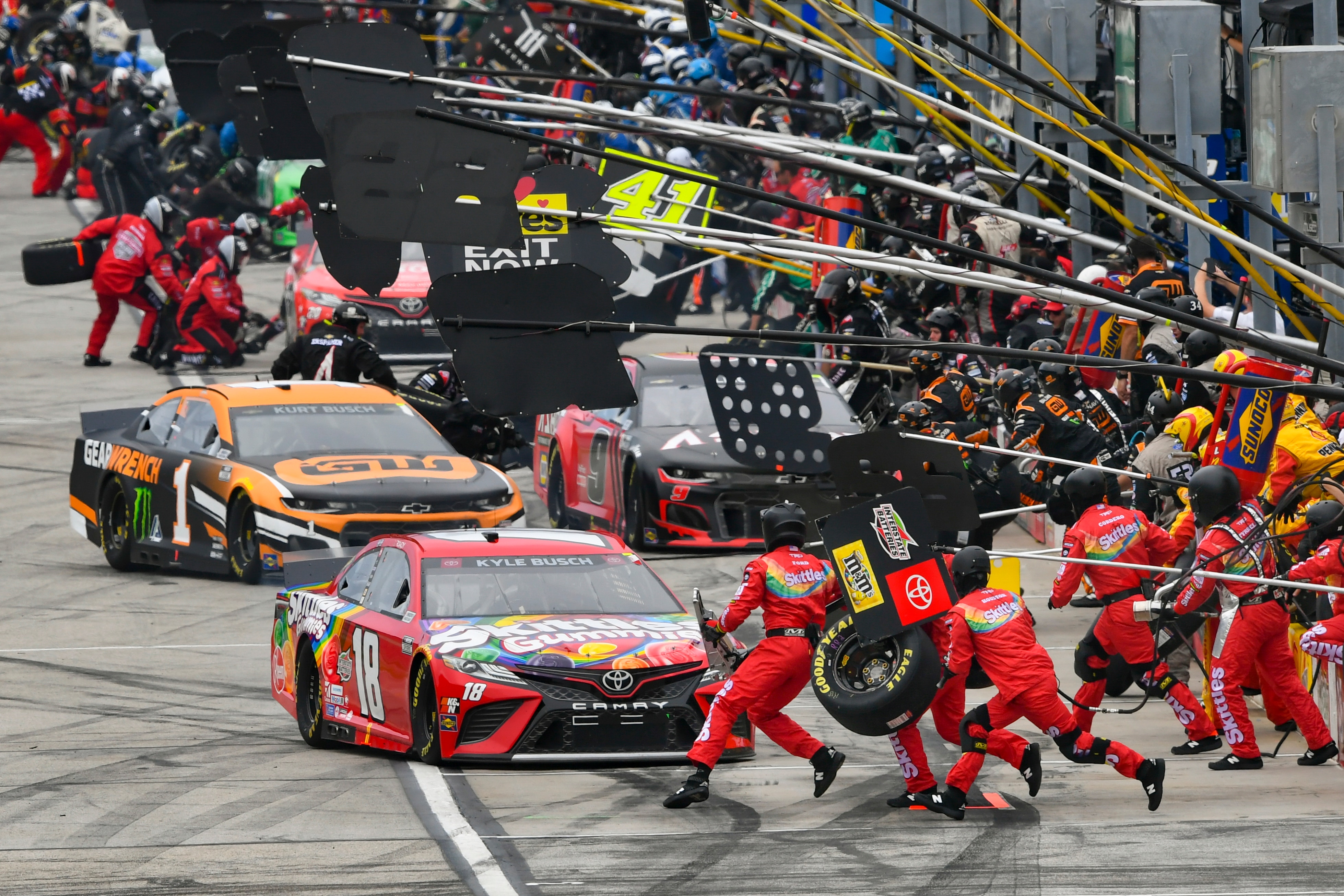 Kyle Busch (18) pits in front of Kurt Busch (1) during a NASCAR Cup Series auto race, Sunday, July, 11, 2021, in Hampton, Ga. (AP Photo/John Amis)