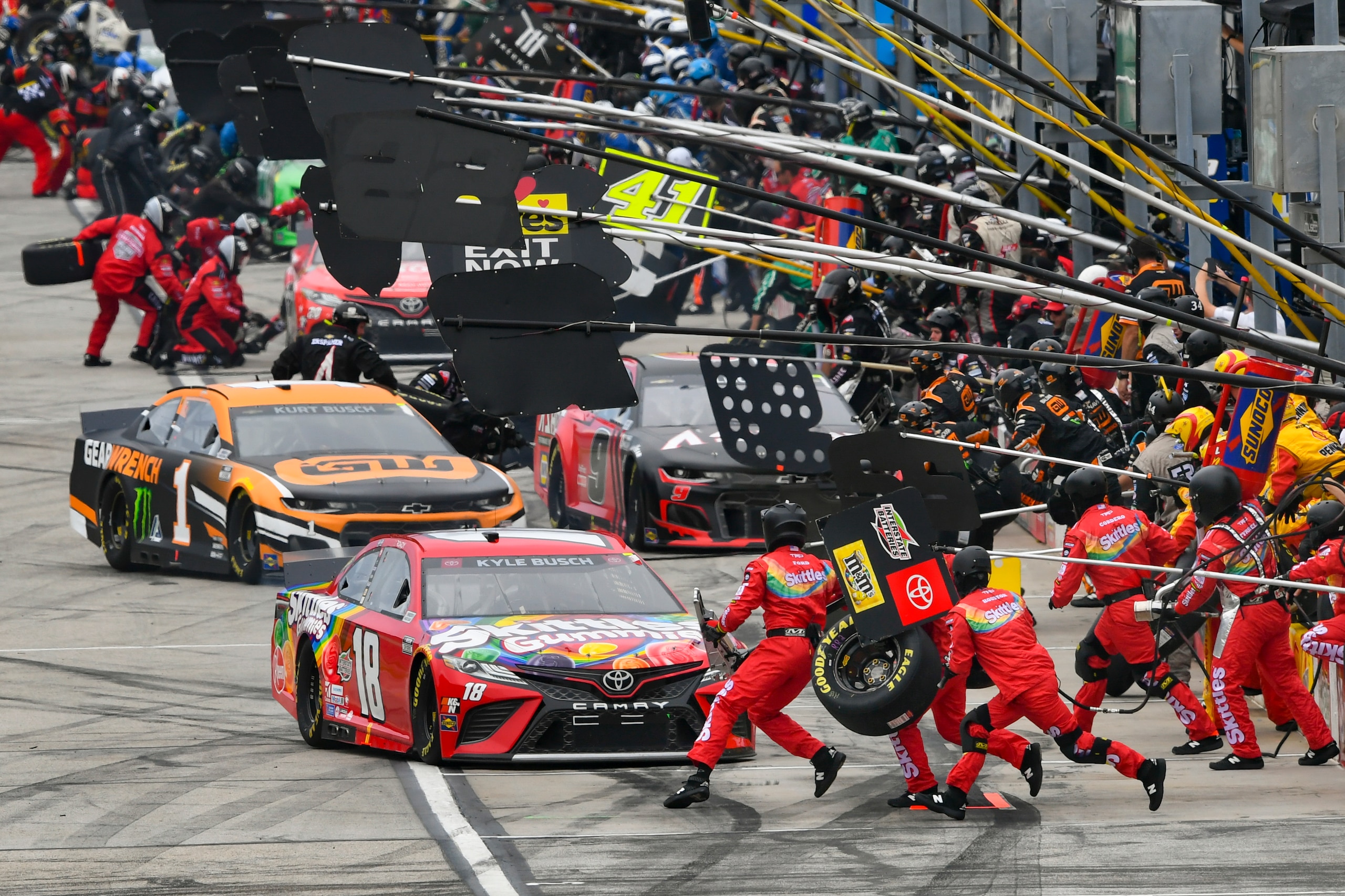 Kyle Busch (18) pits in front of Kurt Busch (1) during a NASCAR Cup Series auto race, Sunday, July, 11, 2021, in Hampton, Ga. (AP Photo/John Amis)