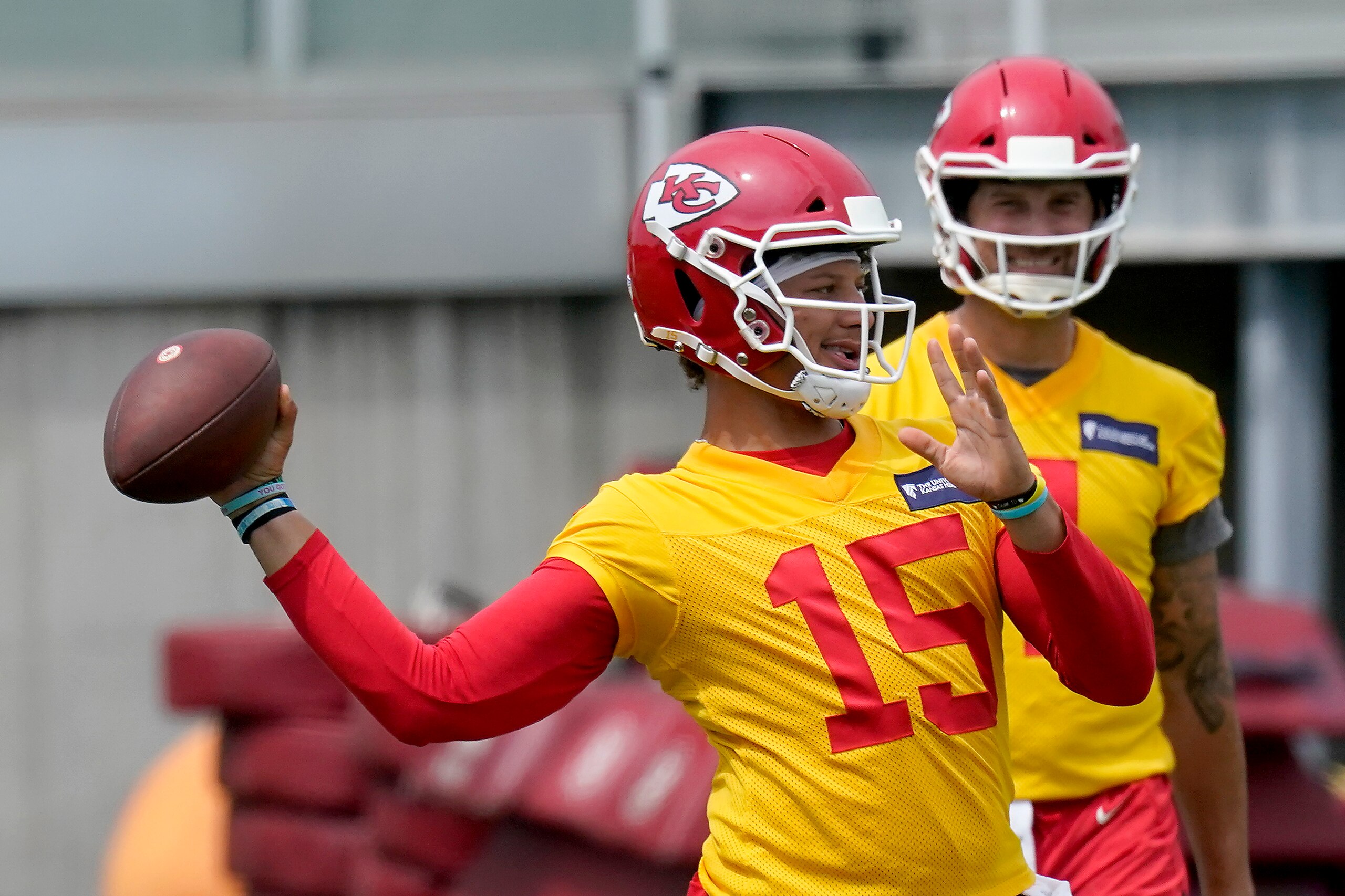 Kansas City Chiefs quarterback Patrick Mahomes (15) throws while teammate Chad Henne waits his turn during the NFL football team's minicamp Wednesday, June 16, 2021, in Kansas City, Mo. (AP Photo/Charlie Riedel)