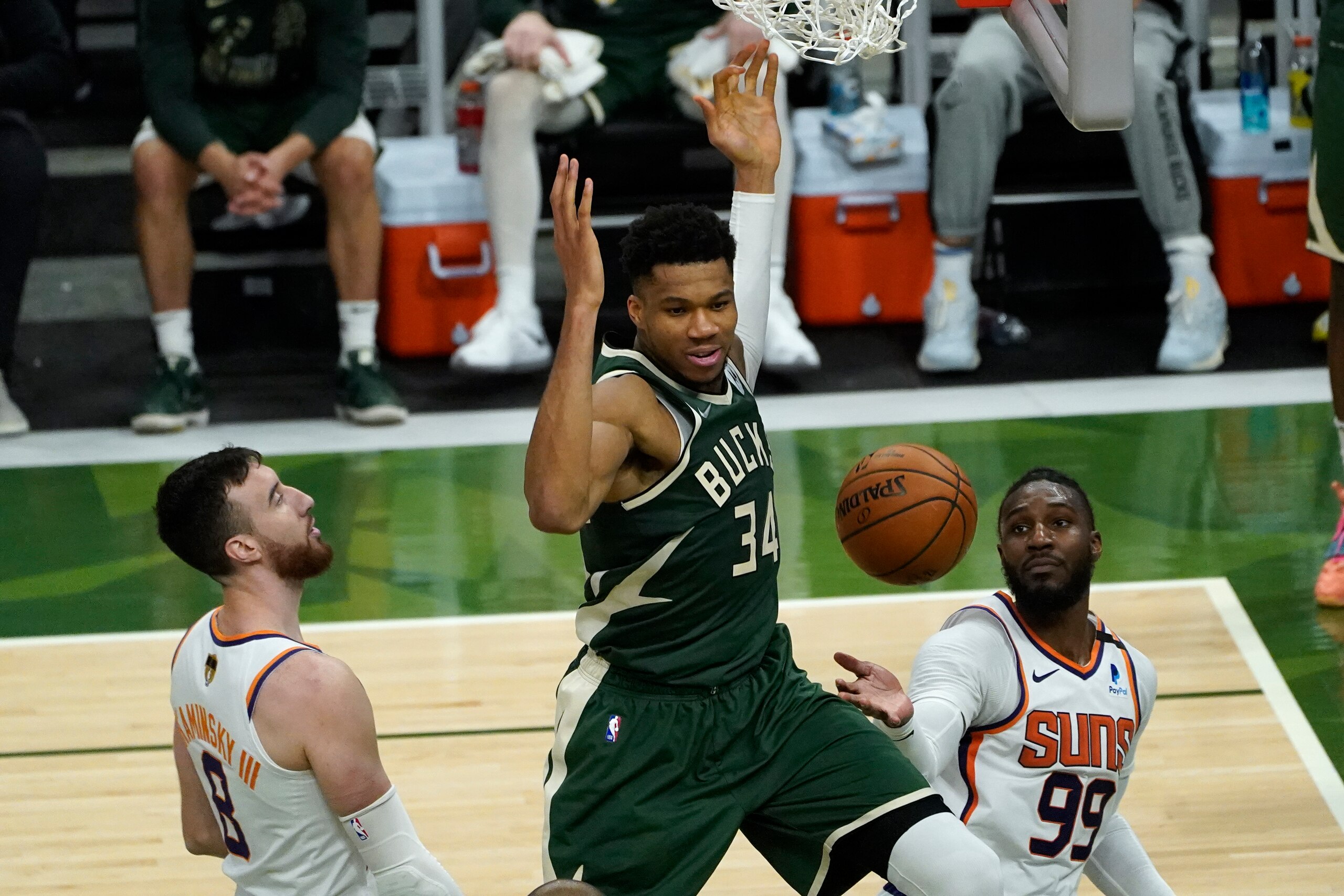 Milwaukee Bucks forward Giannis Antetokounmpo (34) dunks on Phoenix Suns forward Frank Kaminsky (8) and Jae Crowder (99) during the second half of Game 3 of basketball's NBA Finals in Milwaukee, Sunday, July 11, 2021. (AP Photo/Paul Sancya)