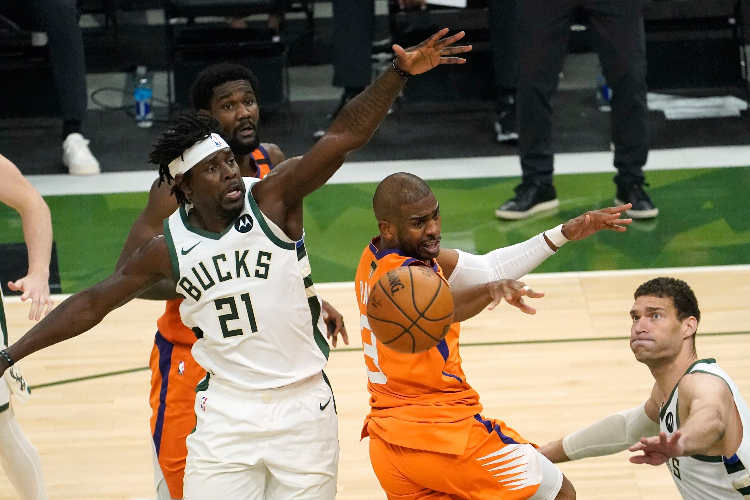 Phoenix Suns guard Chris Paul, center, fights for a rebound with Milwaukee Bucks guard Jrue Holiday (21) and center Brook Lopez, right, during the first half of Game 4 of basketball's NBA Finals in Milwaukee, Wednesday, July 14, 2021. (AP Photo/Paul Sancya)