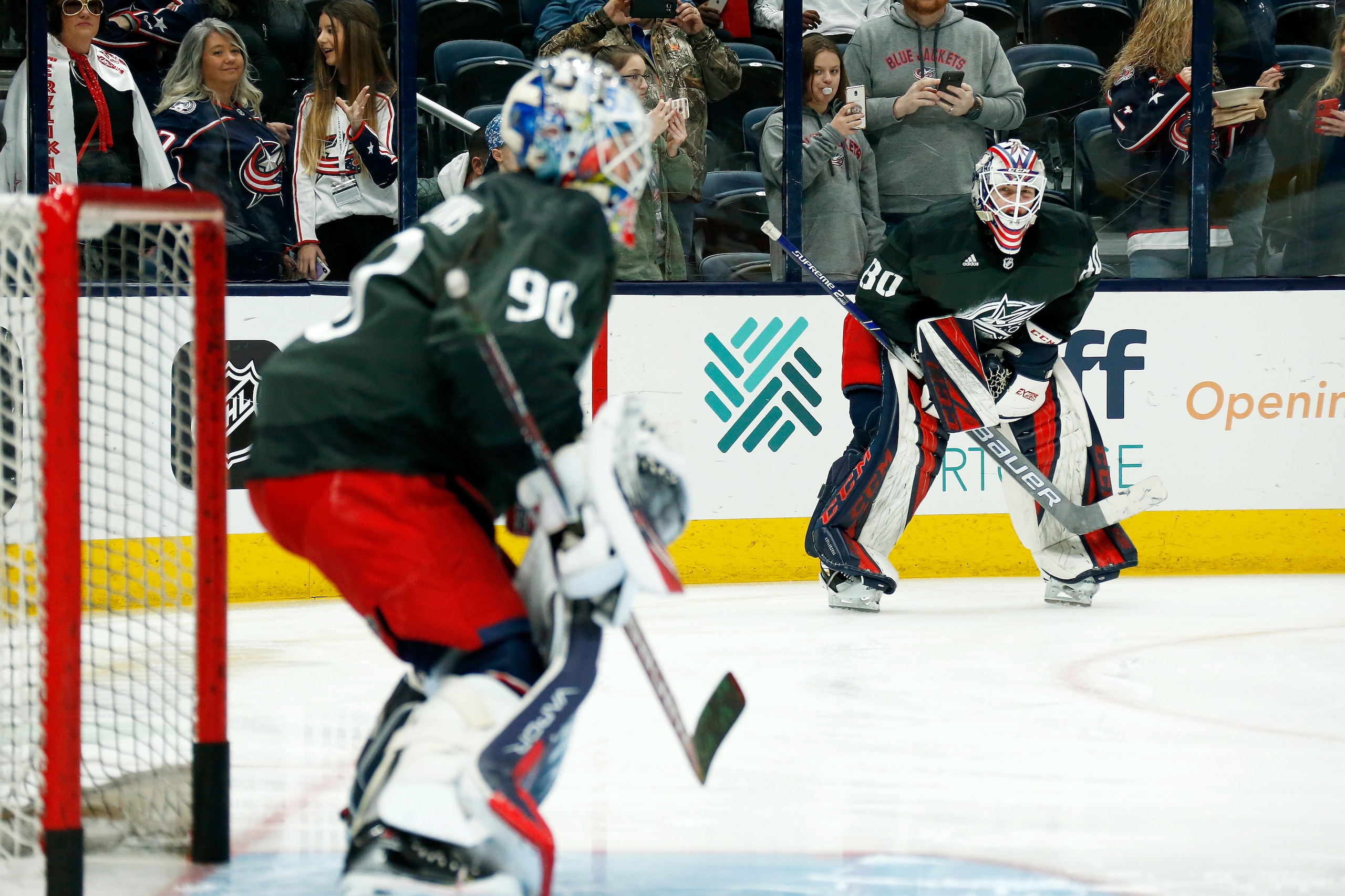 COLUMBUS, OH - JANUARY 16:  Matiss Kivlenieks #80 of the Columbus Blue Jackets watches as Elvis Merzlikins #90 warms up prior to the start of the game against the Carolina Hurricanes on January 16, 2020 at Nationwide Arena in Columbus, Ohio. (Photo by Kirk Irwin/Getty Images)