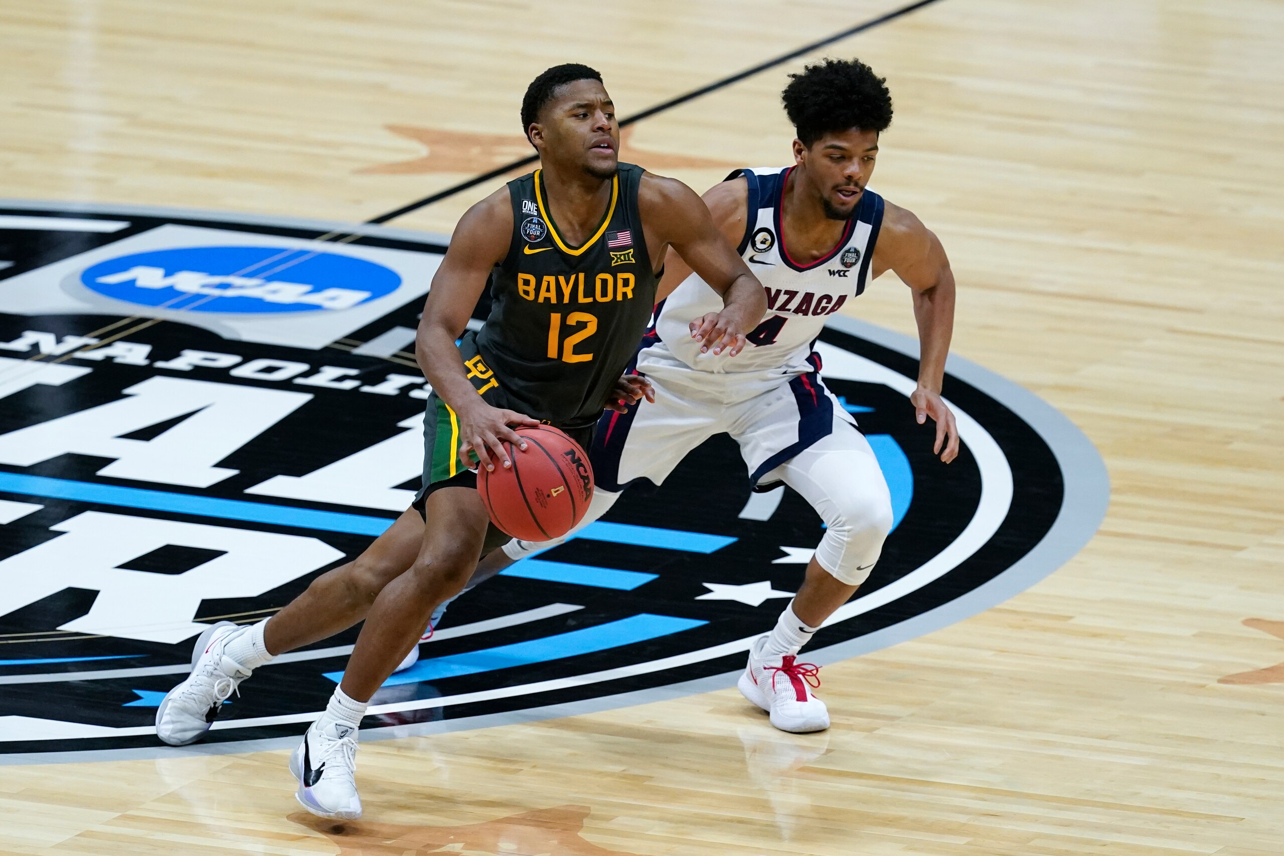 Baylor guard Jared Butler (12) drives up court past Gonzaga guard Aaron Cook (4) during the second half of the championship game in the men's Final Four NCAA college basketball tournament, Monday, April 5, 2021, at Lucas Oil Stadium in Indianapolis. (AP Photo/Darron Cummings)
