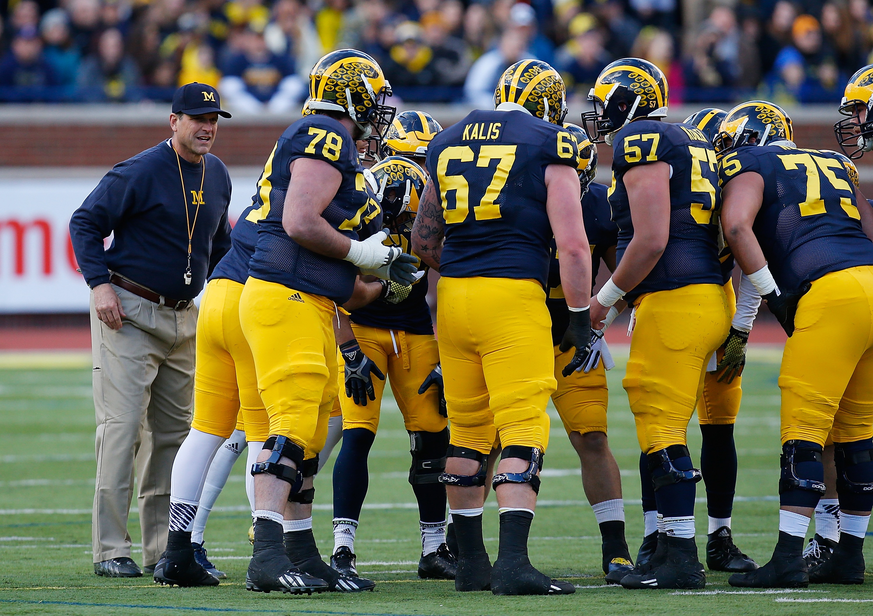 ANN ARBOR, MI - APRIL 01: Head coach Jim Harbaugh of the Michigan Wolverines listens in on a huddle during the Michigan Football Spring Game on April 1, 2016 at Michigan Stadium in Ann Arbor, Michigan.  (Photo by Gregory Shamus/Getty Images)