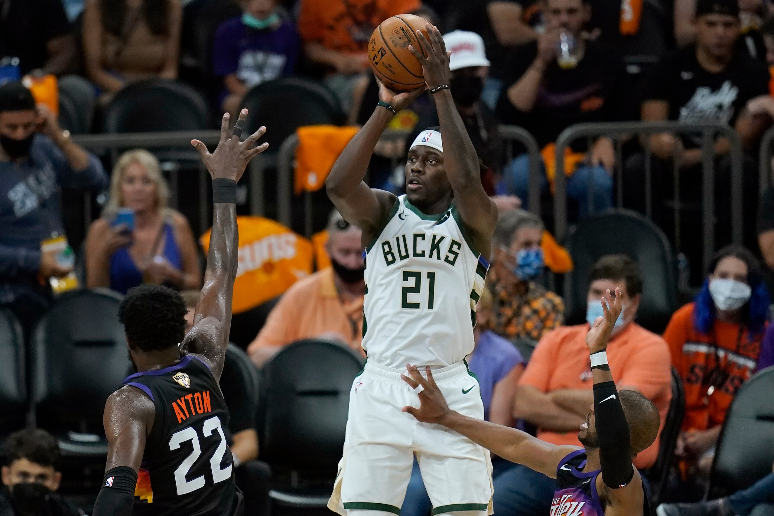 Milwaukee Bucks guard Jrue Holiday (21) shoots against the Phoenix Suns during the second half of Game 5 of basketball's NBA Finals, Saturday, July 17, 2021, in Phoenix. (AP Photo/Ross D. Franklin)