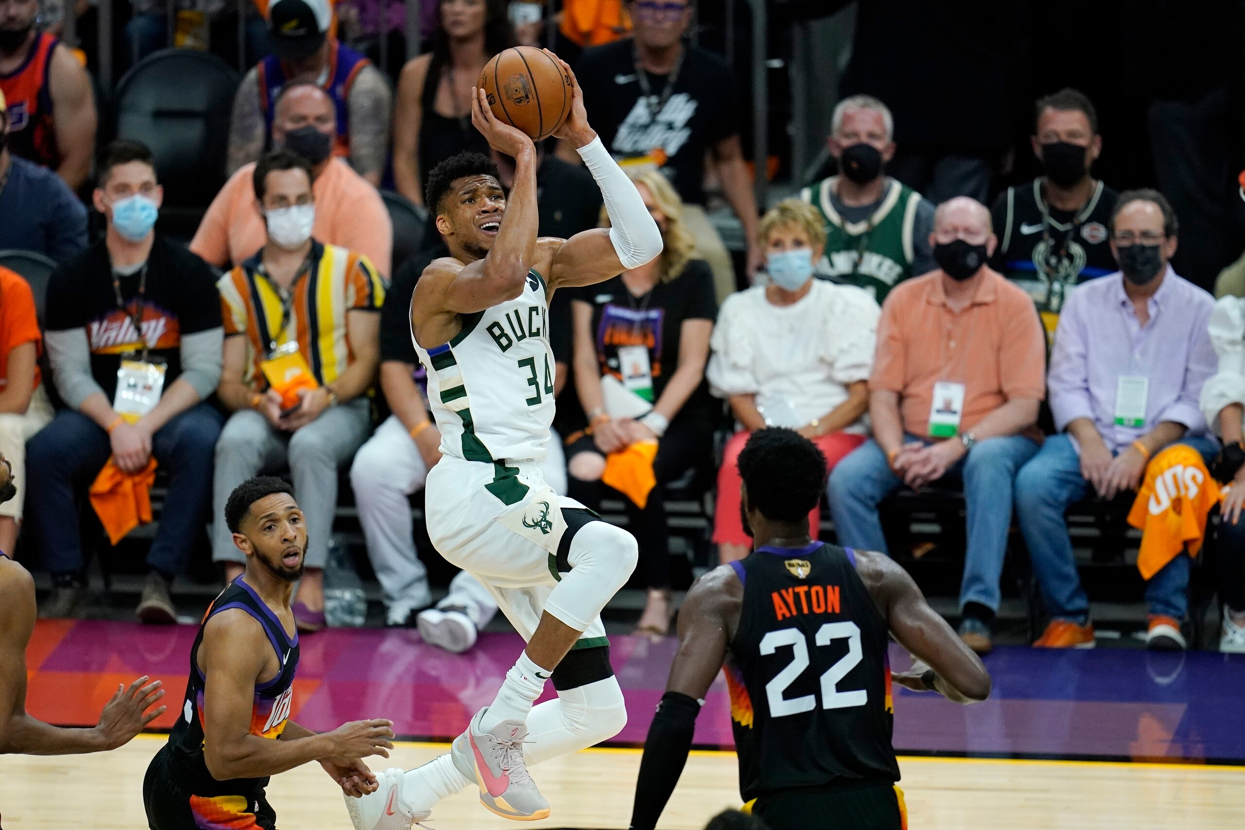 Milwaukee Bucks forward Giannis Antetokounmpo (34) shoots against Phoenix Suns guard Cameron Payne, left, and Suns center Deandre Ayton (22) during the first half of Game 5 of basketball's NBA Finals, Saturday, July 17, 2021, in Phoenix. (AP Photo/Ross D. Franklin)
