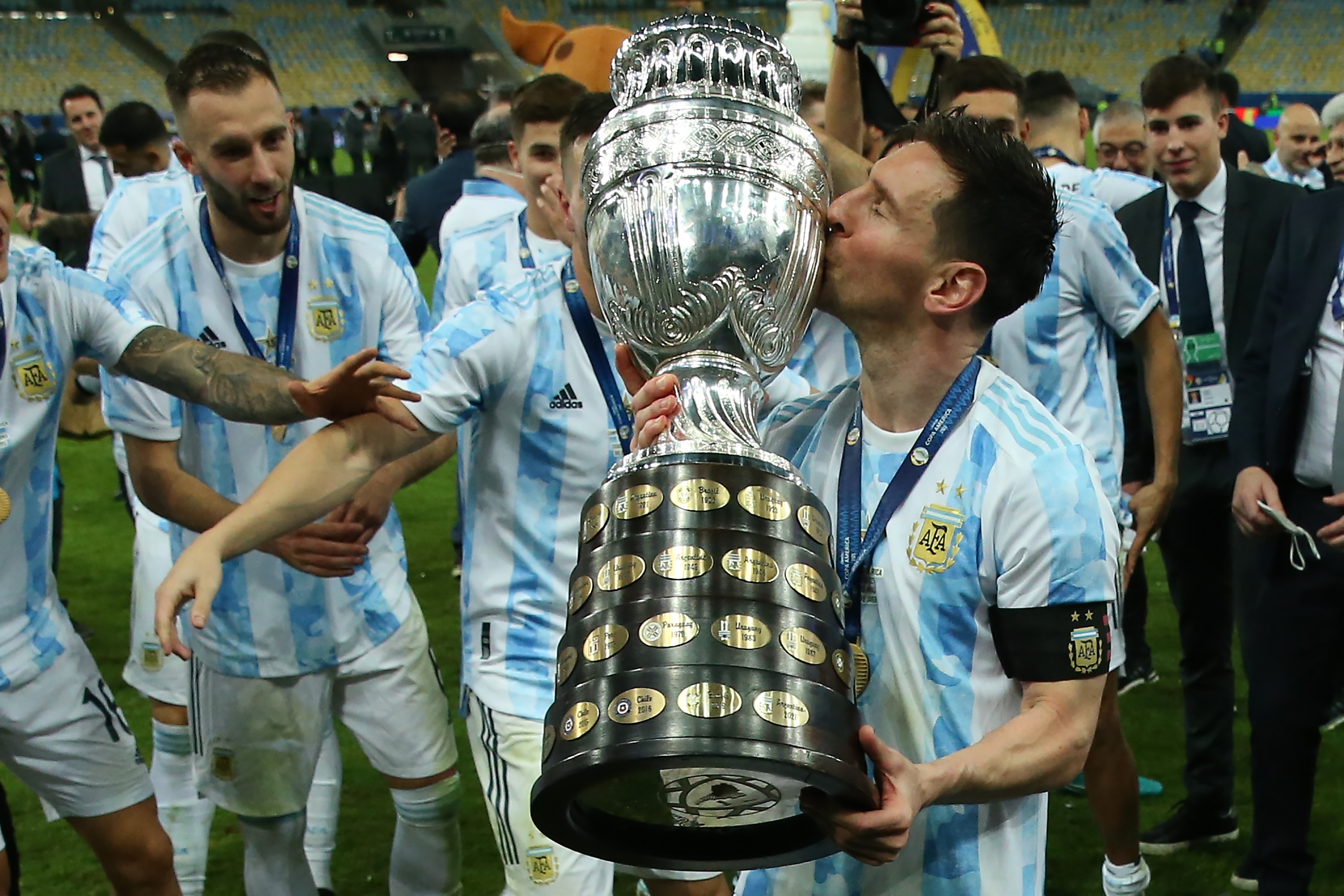 RIO DE JANEIRO, BRAZIL - JULY 10: Lionel Messi of Argentina kisses the trophy as he celebrates with teammates after winning the final of Copa America Brazil 2021 between Brazil and Argentina at Maracana Stadium on July 10, 2021 in Rio de Janeiro, Brazil. (Photo by Alexandre Schneider/Getty Images)
