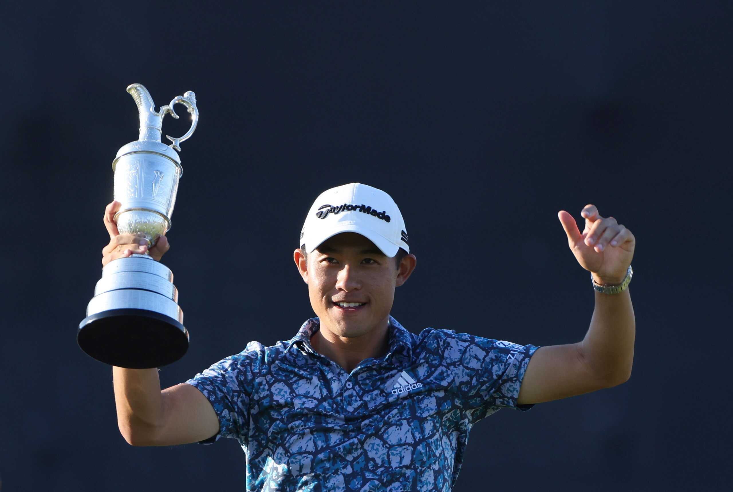United States' Collin Morikawa holds up the claret jug trophy as he poses for photographers on the 18th green after winning the British Open Golf Championship at Royal St George's golf course Sandwich, England, Sunday, July 18, 2021. (AP Photo/Ian Walton)