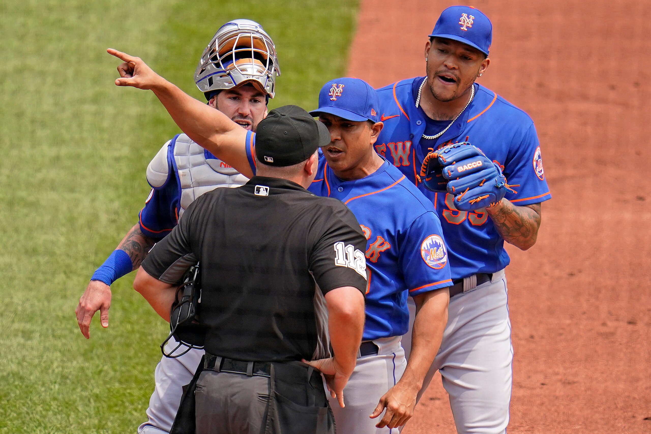 New York Mets manager Luis Rojas, center, makes his point to umpire Jeremy Riggs (112) with catcher Tomas Nido, left rear, and starting pitcher Taijuan Walker, right rear, looking on during the first inning of a baseball game in Pittsburgh, Sunday, July 18, 2021. Rojas was ejected from the game. (AP Photo/Gene J. Puskar)