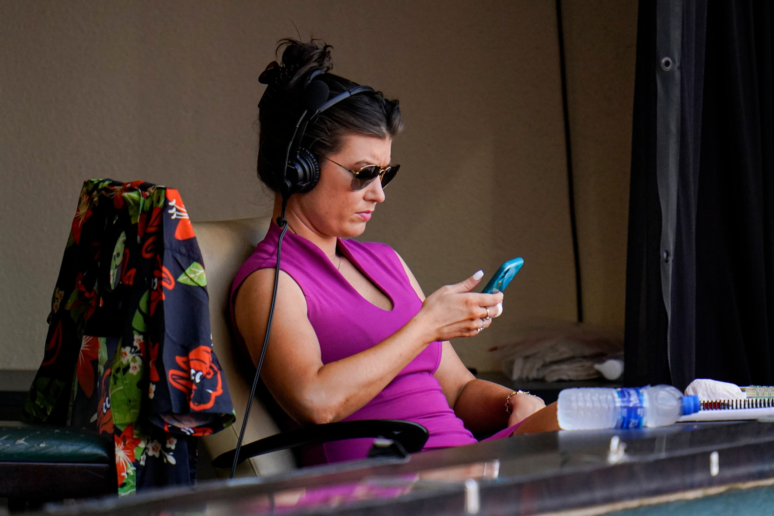 Melanie Newman, play-by-play broadcaster for the Baltimore Orioles, looks at her phone between innings during the fourth inning of a baseball game between the Baltimore Orioles and the Chicago White Sox, Saturday, July 10, 2021, in Baltimore. (AP Photo/Julio Cortez) Melanie Newman, play-by-play broadcaster for the Baltimore Orioles, looks at her phone between innings during the fourth inning of a baseball game between the Baltimore Orioles and the Chicago White Sox, Saturday, July 10, 2021, in Baltimore. (AP Photo/Julio Cortez)