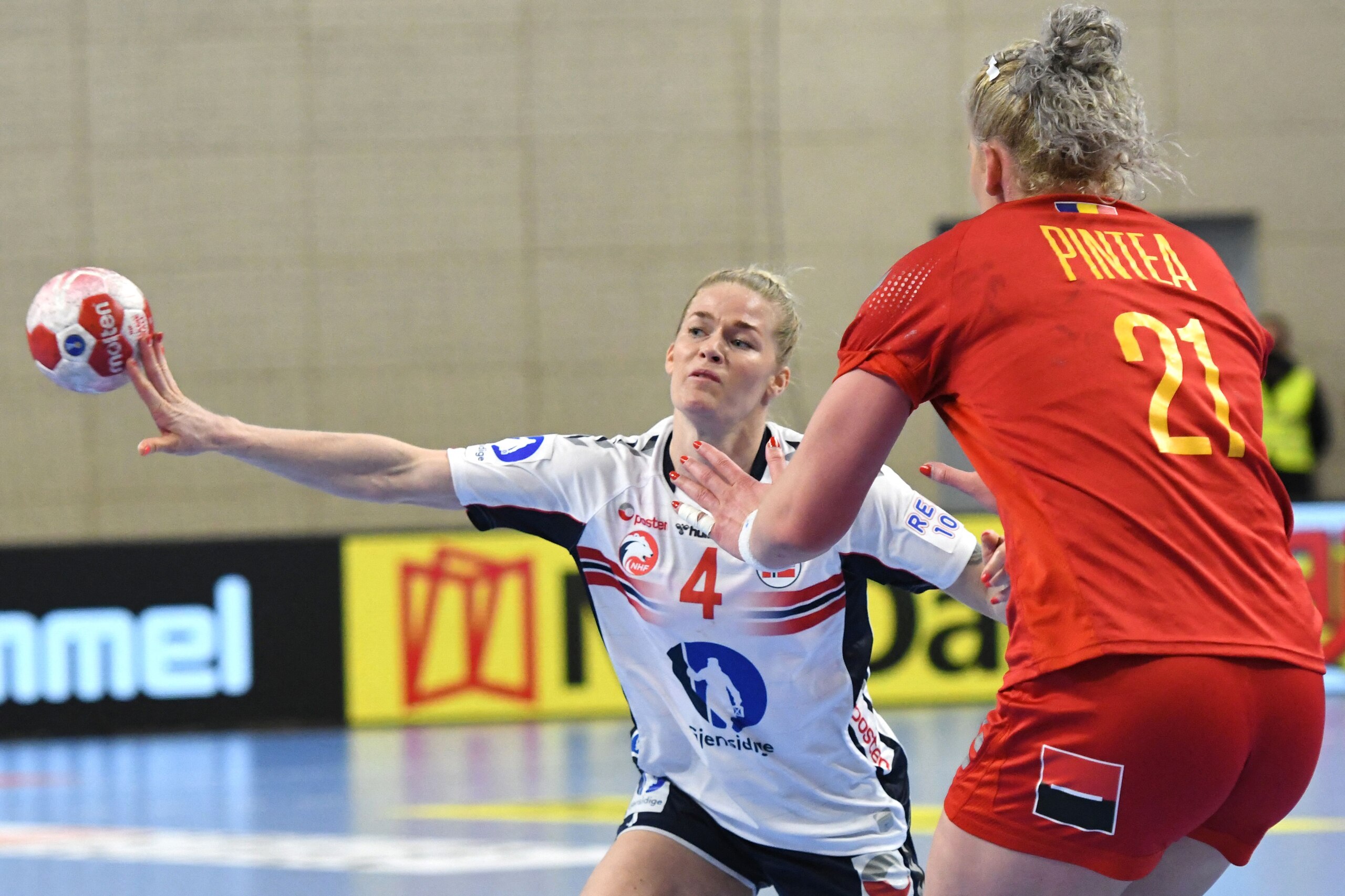 Norway's left back Veronica Egebakken Kristiansen (L) and Romania's pivot Crina Elena Pintea (R) fight for the ball during the 2020 Tokyo Olympics women's qualifying handball match between Norway and Romania in Podgorica on March 20, 2021. (Photo by SAVO PRELEVIC / AFP) (Photo by SAVO PRELEVIC/AFP via Getty Images)