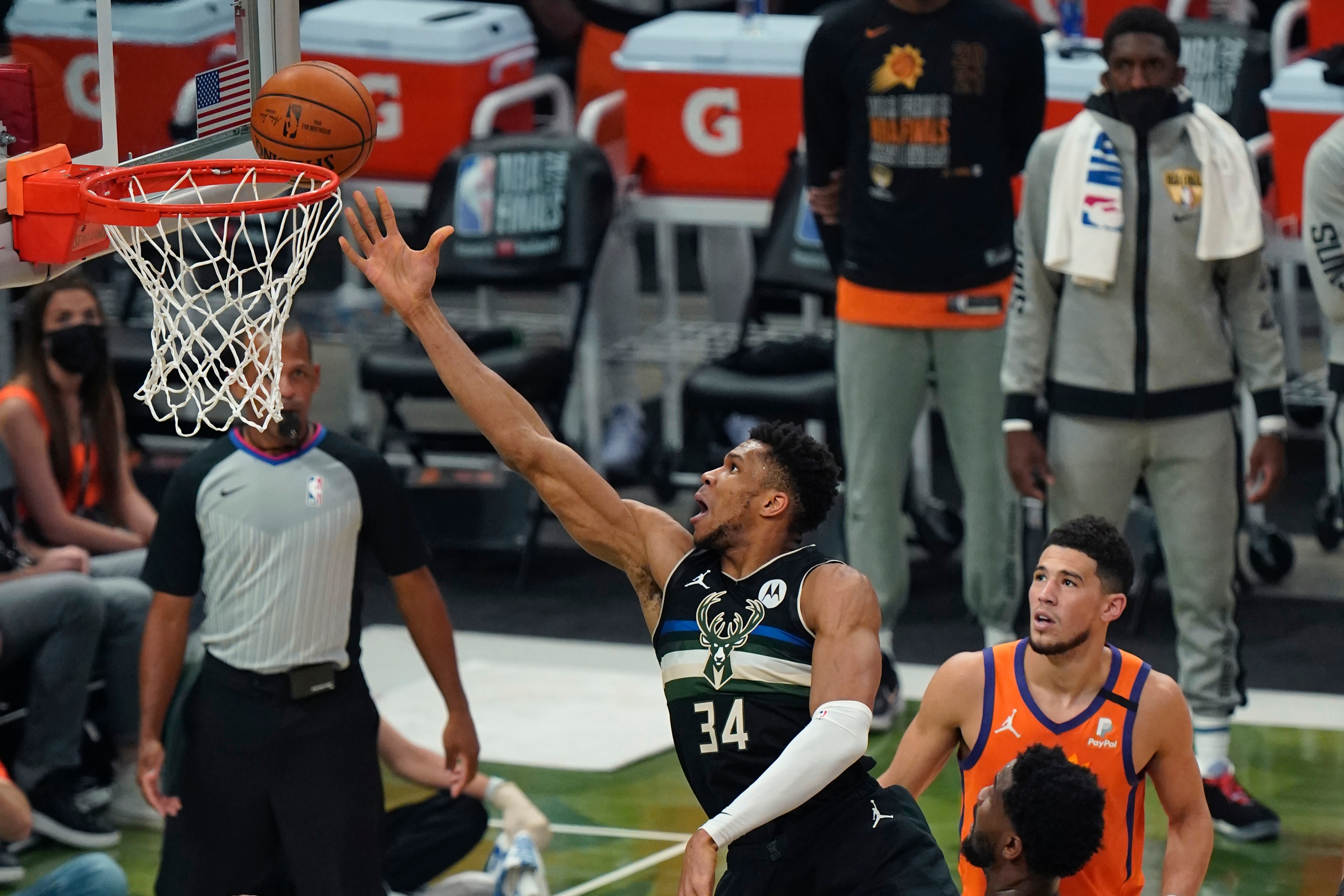 Milwaukee Bucks forward Giannis Antetokounmpo (34) goes to the basket over Phoenix Suns guard Devin Booker and Phoenix Suns center Deandre Ayton, bottom right, during the first half of Game 6 of basketball's NBA Finals in Milwaukee, Tuesday, July 20, 2021. (AP Photo/Paul Sancya)