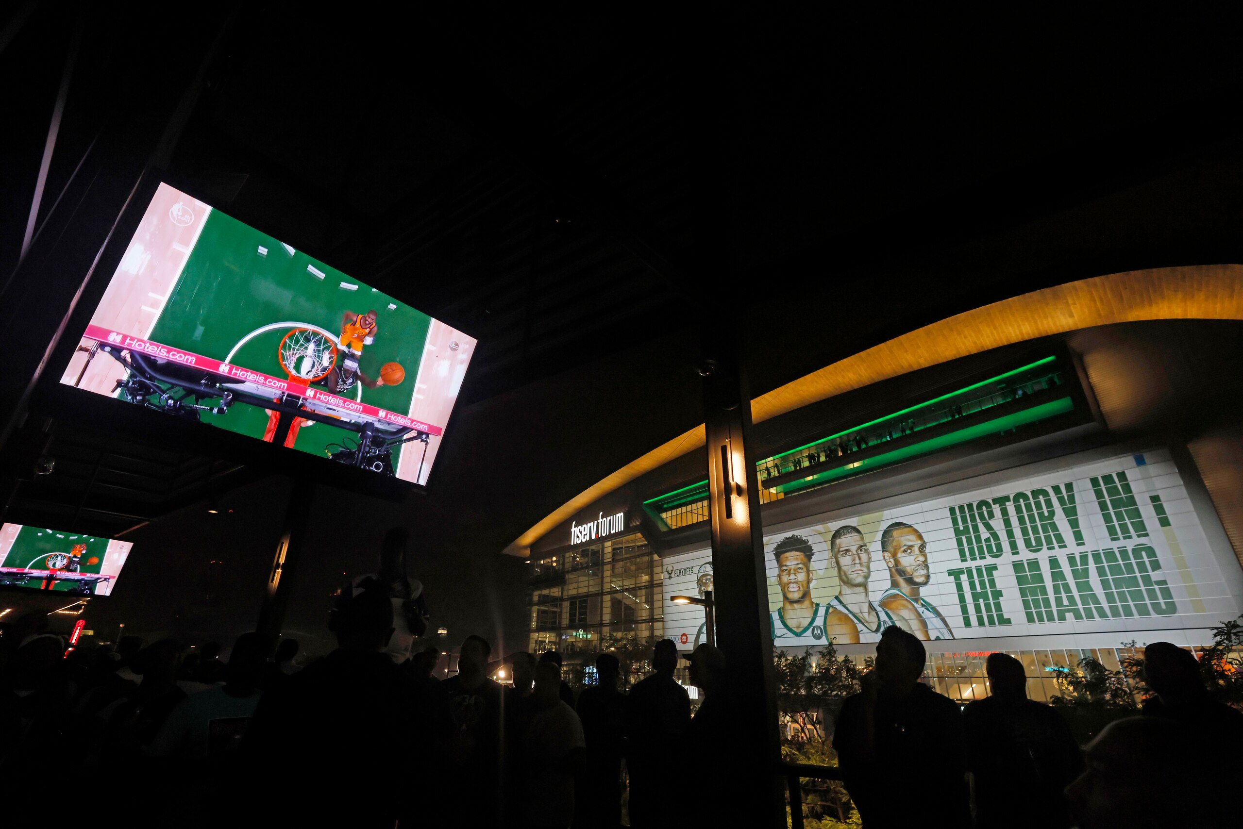 Fans watch a television coverage of the Milwaukee Bucks and the Phoenix Suns playing in Game 6 of the NBA basketball finals Tuesday, July 20, 2021, in Milwaukee. The Bucks won the championship. (AP Photo/Jeffrey Phelps)