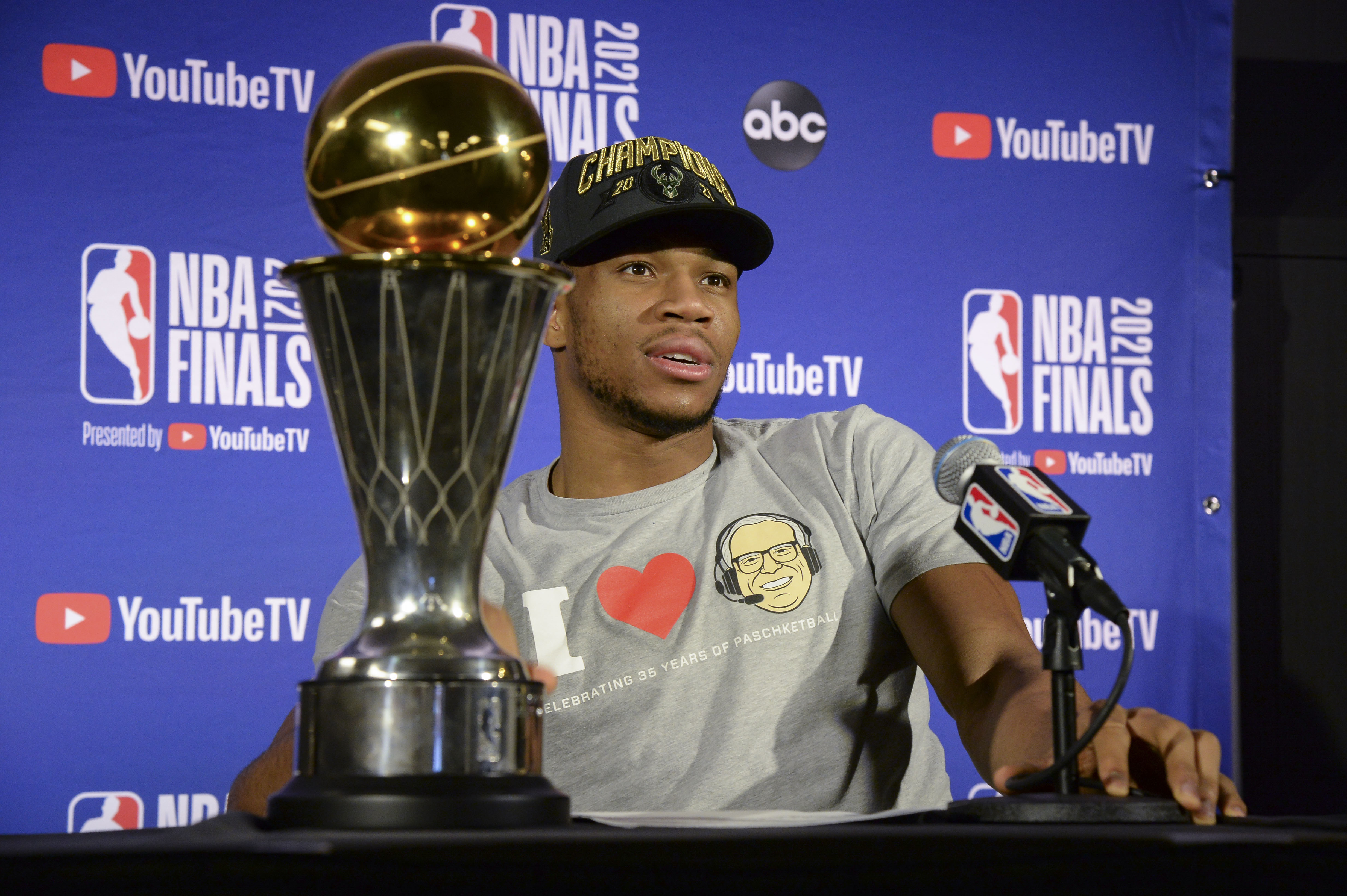 MILWAUKEE, WI - JULY 20: Giannis Antetokounmpo #34 of the Milwaukee Bucks holds the Bill Russell NBA Finals MVP Award and Larry O'Brien Trophy as he talks to the media after defeating the Phoenix Suns in Game Six to win the 2021 NBA Finals  on July 20, 2021 at the Fiserv Forum in Milwaukee, Wisconsin. NOTE TO USER: User expressly acknowledges and agrees that, by downloading and or using this Photograph, user is consenting to the terms and conditions of the Getty Images License Agreement. Mandatory Copyright Notice: Copyright 2021 NBAE (Photo by Andrew D. Bernstein/NBAE via Getty Images).