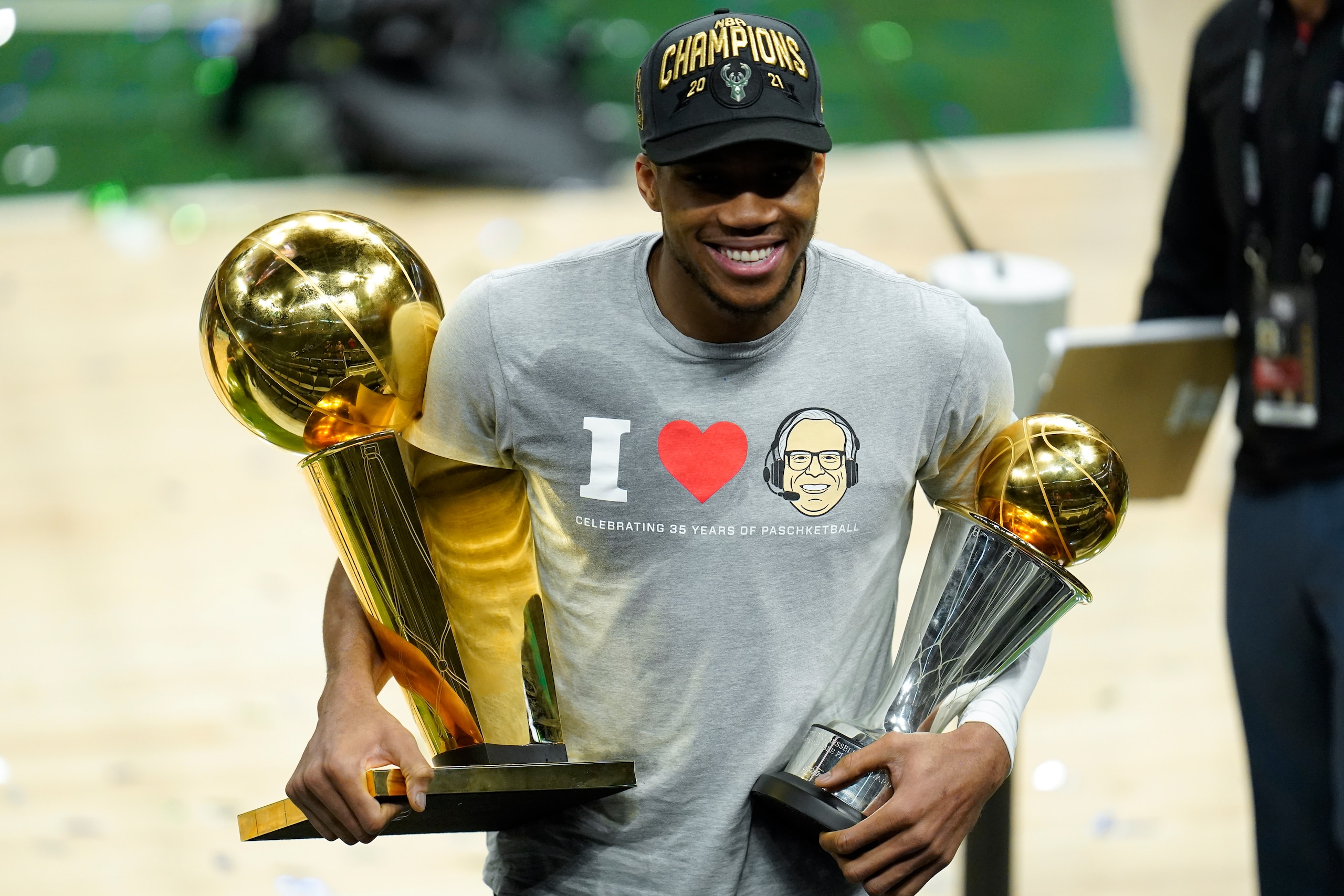 Milwaukee Bucks forward Giannis Antetokounmpo smiles while holding the NBA Championship trophy, left, and Most Valuable Player trophy after defeating the Phoenix Suns in Game 6 of basketball's NBA Finals in Milwaukee, Tuesday, July 20, 2021. The Bucks won 105-98. (AP Photo/Paul Sancya) Milwaukee Bucks forward Giannis Antetokounmpo smiles while holding the NBA Championship trophy, left, and Most Valuable Player trophy after defeating the Phoenix Suns in Game 6 of basketball's NBA Finals in Milwaukee, Tuesday, July 20, 2021. The Bucks won 105-98. (AP Photo/Paul Sancya)
