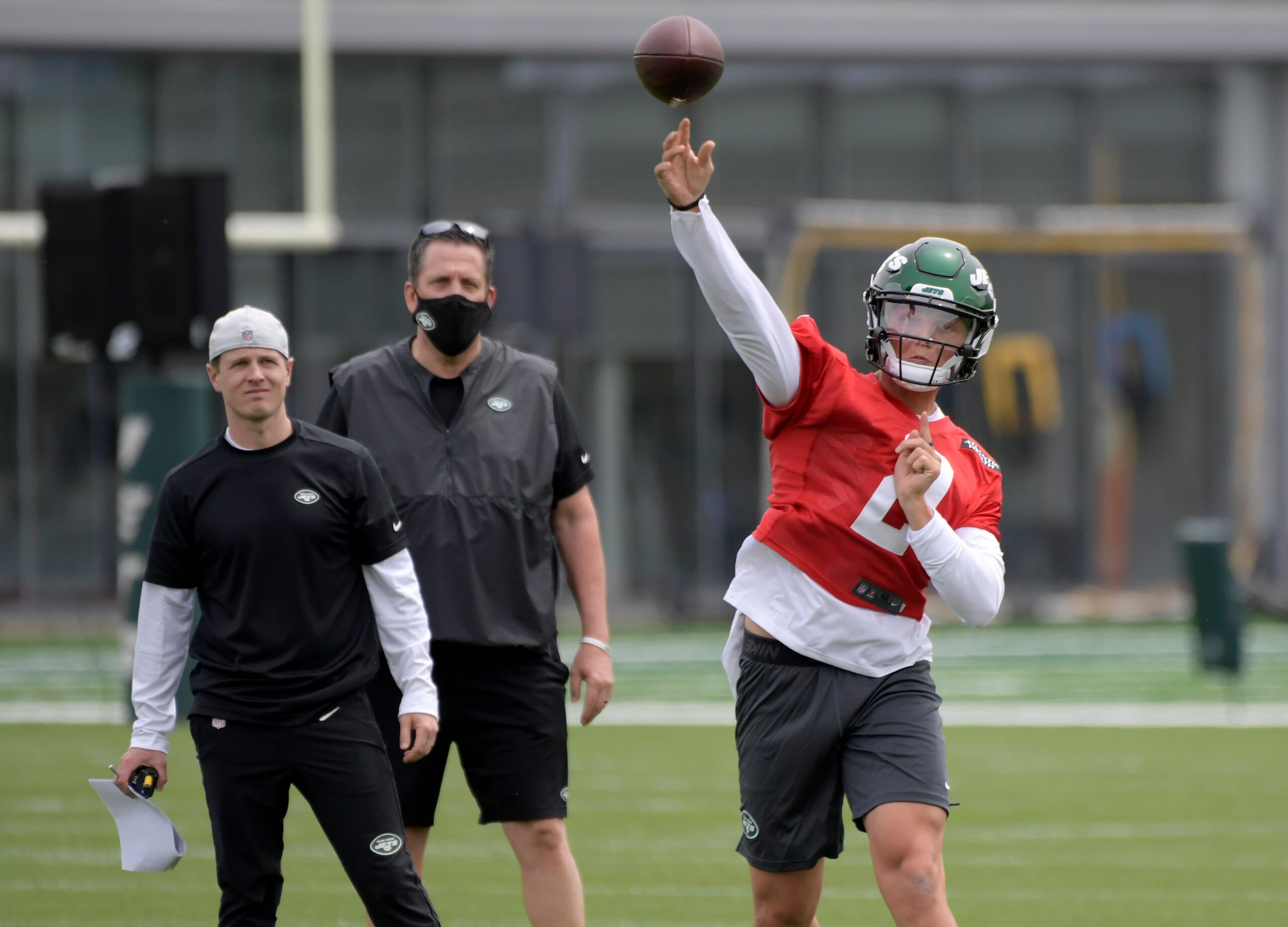 CORRECTS TO OFFENSIVE COORDINATOR MIKE LAFLEUR, LEFT, NOT QUARTERBACKS COACH ROB CALABRESE - New York Jets first-round draft pick Zach Wilson (2) works out as offensive coordinator Mike Lafleur, left, and passing game specialist Greg Knapp, center, look on during NFL football rookie camp, Friday, May 7, 2021, in Florham Park, N.J. (AP Photo/Bill Kostroun) CORRECTS TO OFFENSIVE COORDINATOR MIKE LAFLEUR, LEFT, NOT QUARTERBACKS COACH ROB CALABRESE - New York Jets first-round draft pick Zach Wilson (2) works out as offensive coordinator Mike Lafleur, left, and passing game specialist Greg Knapp, center, look on during NFL football rookie camp, Friday, May 7, 2021, in Florham Park, N.J. (AP Photo/Bill Kostroun)