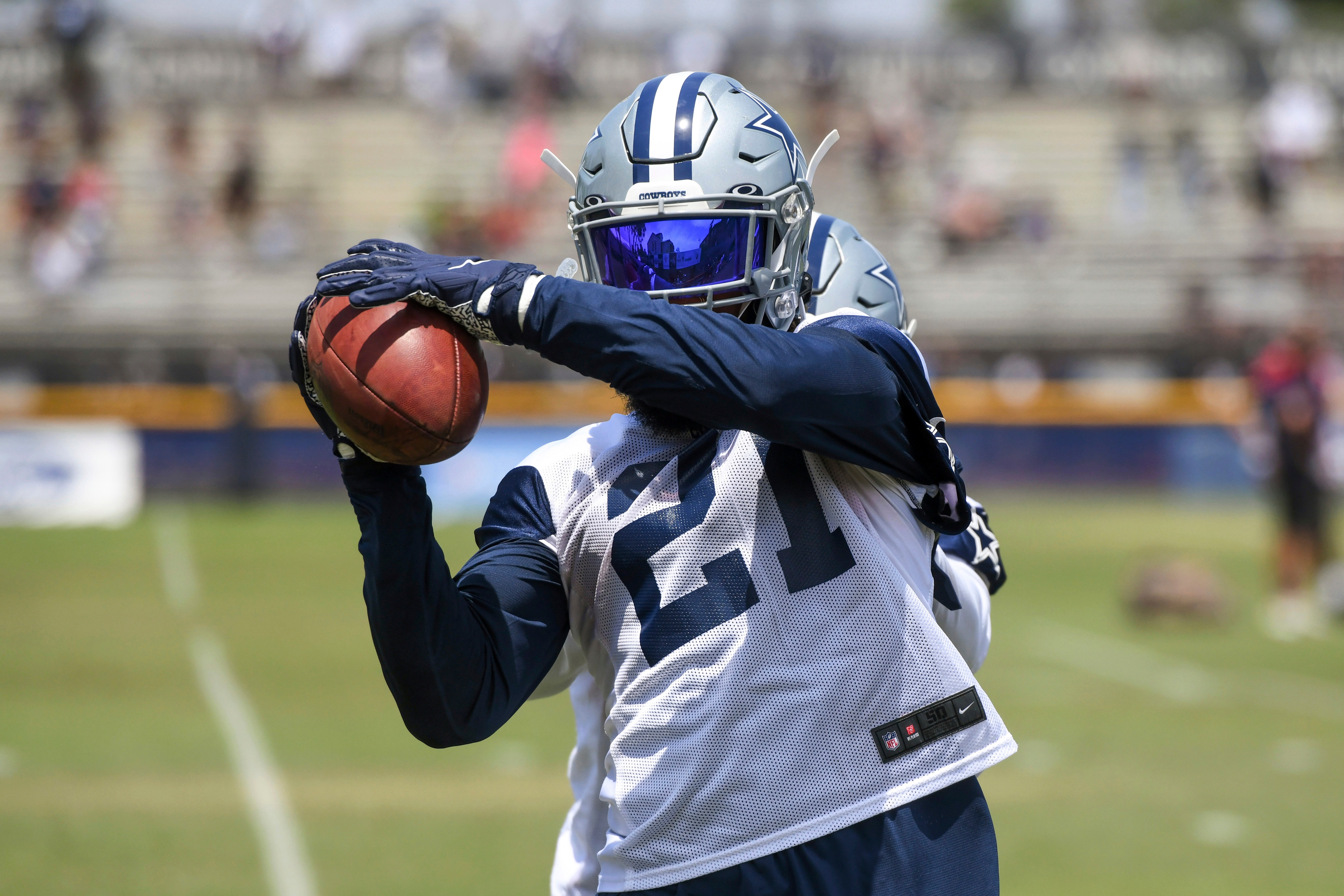 Dallas Cowboys running back Ezekiel Elliott catches the football from a passing machine following practice at the NFL football team's training camp in Oxnard, Calif., Thursday, July 22, 2021. (AP Photo/Michael Owen Baker)