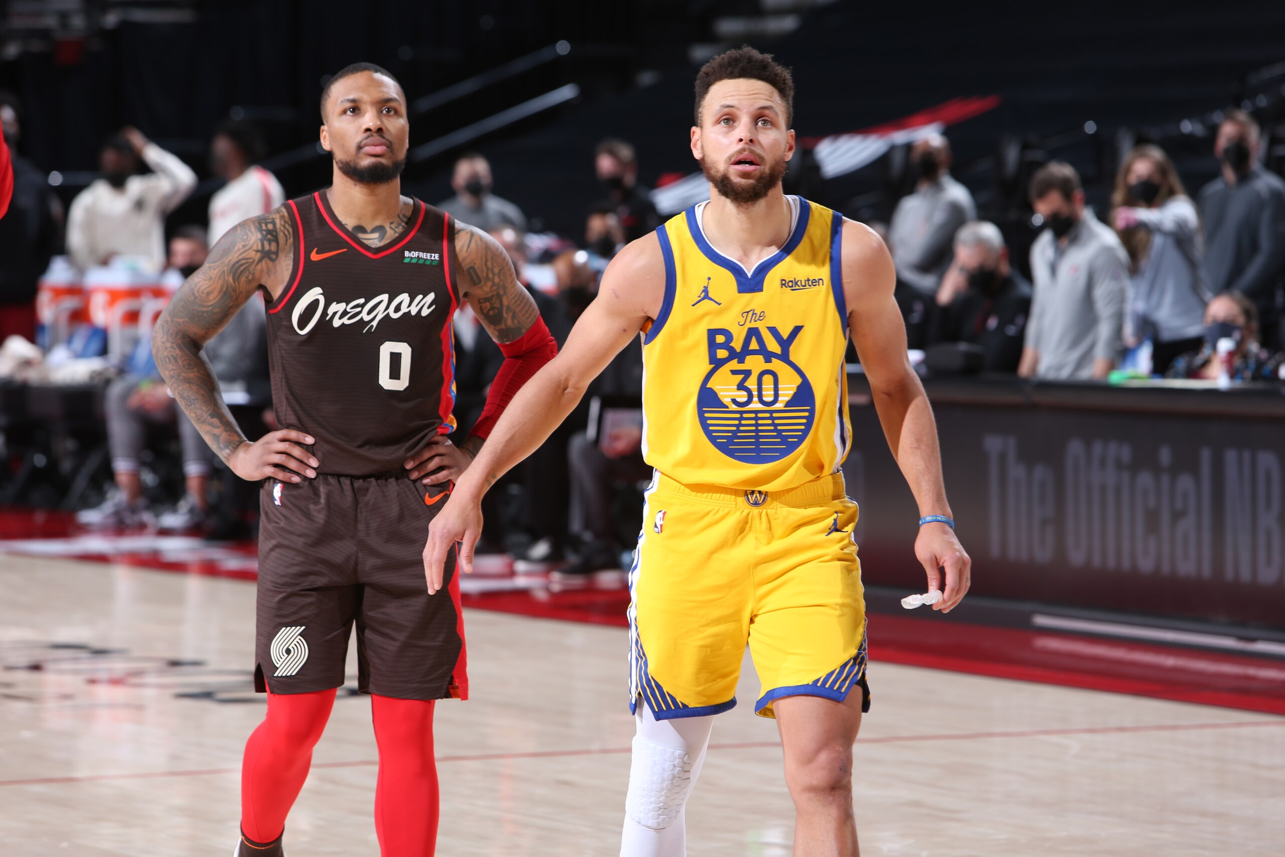 PORTLAND, OR - MARCH 3: Damian Lillard #0 of the Portland Trail Blazers and Stephen Curry #30 of the Golden State Warriors look on during the game on March 3, 2021 at the Moda Center Arena in Portland, Oregon. NOTE TO USER: User expressly acknowledges and agrees that, by downloading and or using this photograph, user is consenting to the terms and conditions of the Getty Images License Agreement. Mandatory Copyright Notice: Copyright 2021 NBAE (Photo by Sam Forencich/NBAE via Getty Images)