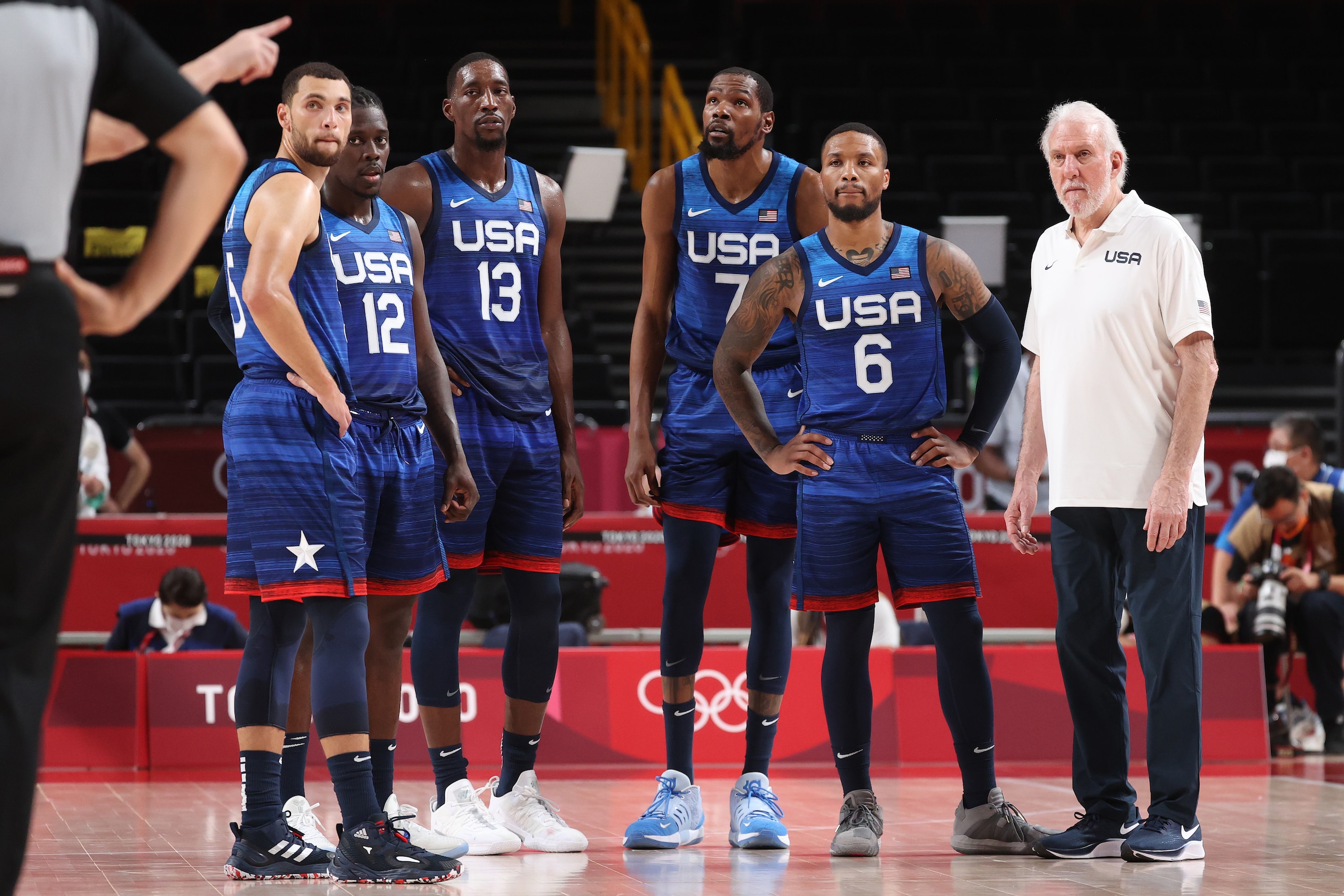 SAITAMA, JAPAN - JULY 25: Zachary Lavine #5, Jrue Holiday #12, Bam Adebayo #13, Kevin Durant #7, Damian Lillard #6 and Head Coach Gregg Popovich of Team United States of America look on in disbelief during their game against France in Men's Preliminary Round Group B action on day two of the Tokyo 2020 Olympic Games at Saitama Super Arena on July 25, 2021 in Saitama, Japan. (Photo by Gregory Shamus/Getty Images)
