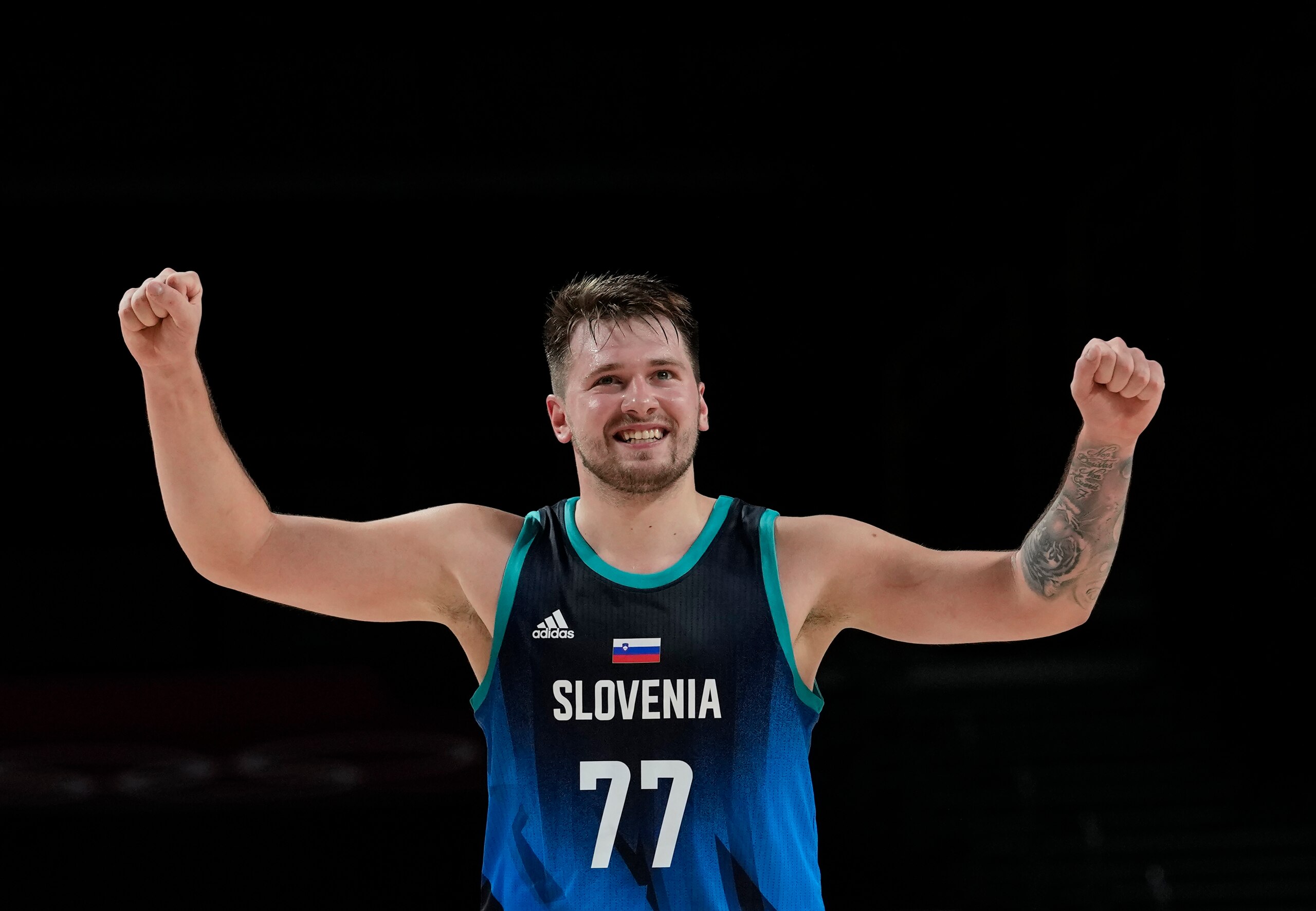 Slovenia's Luka Doncic (77) celebrates scoring by a teammate during men's basketball preliminary round game against Argentina at the 2020 Summer Olympics, Monday, July 26, 2021, in Saitama, Japan. (AP Photo/Eric Gay)