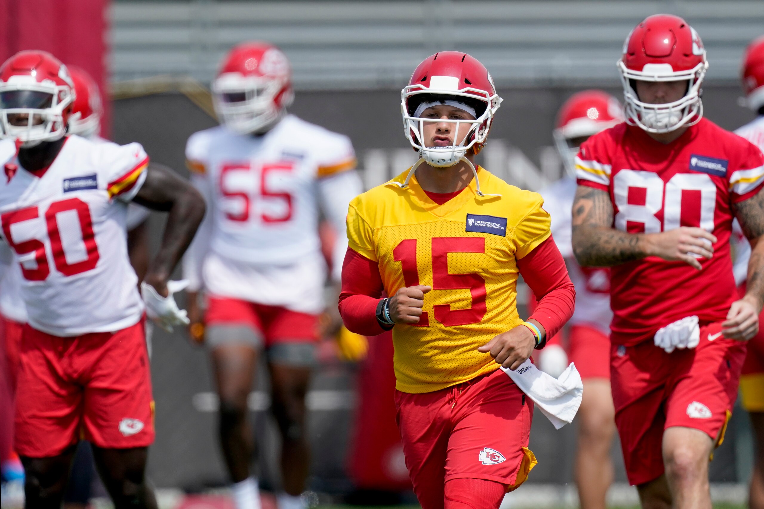 Kansas City Chiefs quarterback Patrick Mahomes (15) warms up with teammates during the NFL football team's minicamp Wednesday, June 16, 2021, in Kansas City, Mo. (AP Photo/Charlie Riedel)